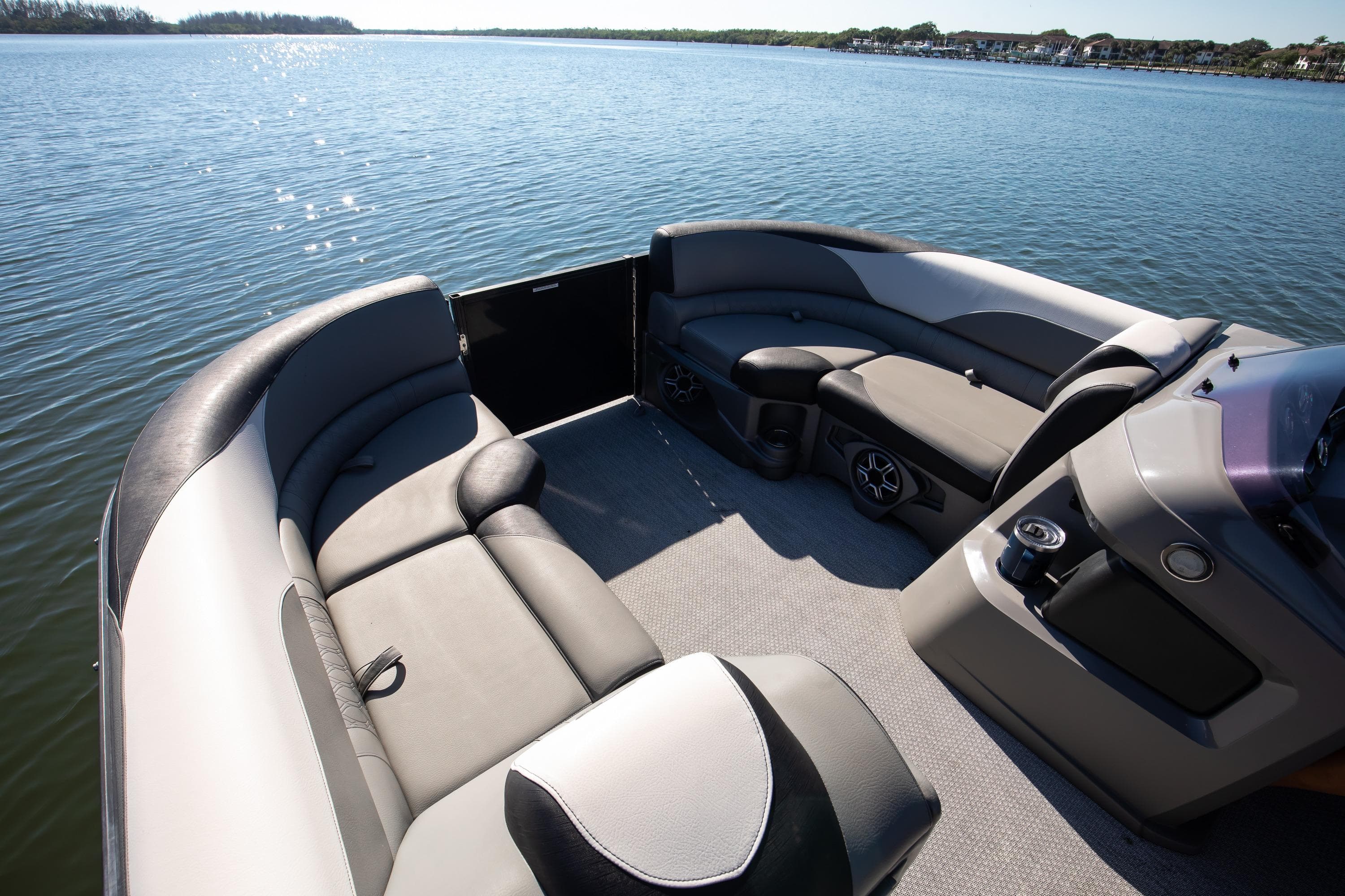 2021 Avalon LSZ Quad Lounger boat interior with comfortable seating on a serene lake.