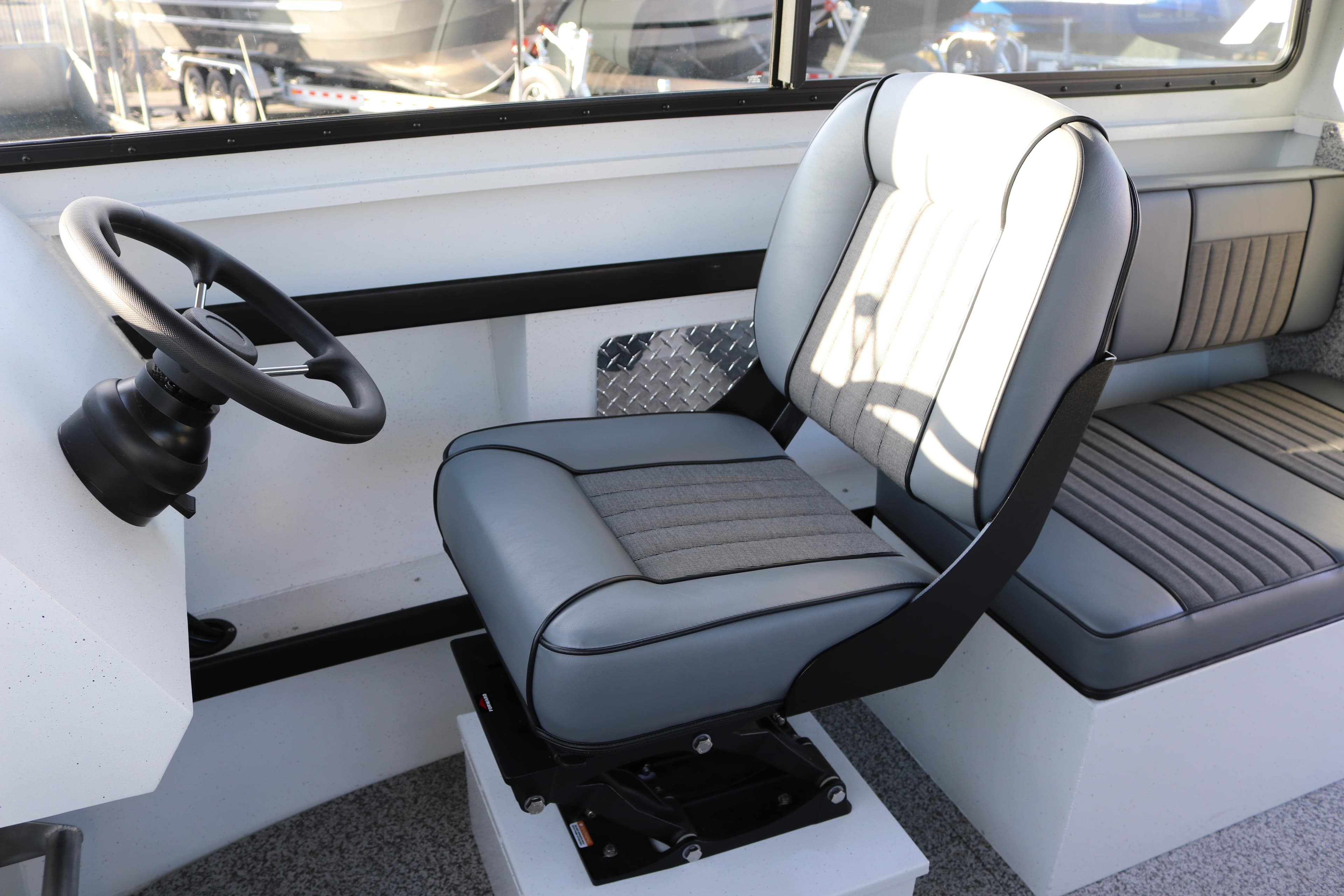 Interior of 2026 Alumaweld Horizon 26 boat with steering wheel and seating.
