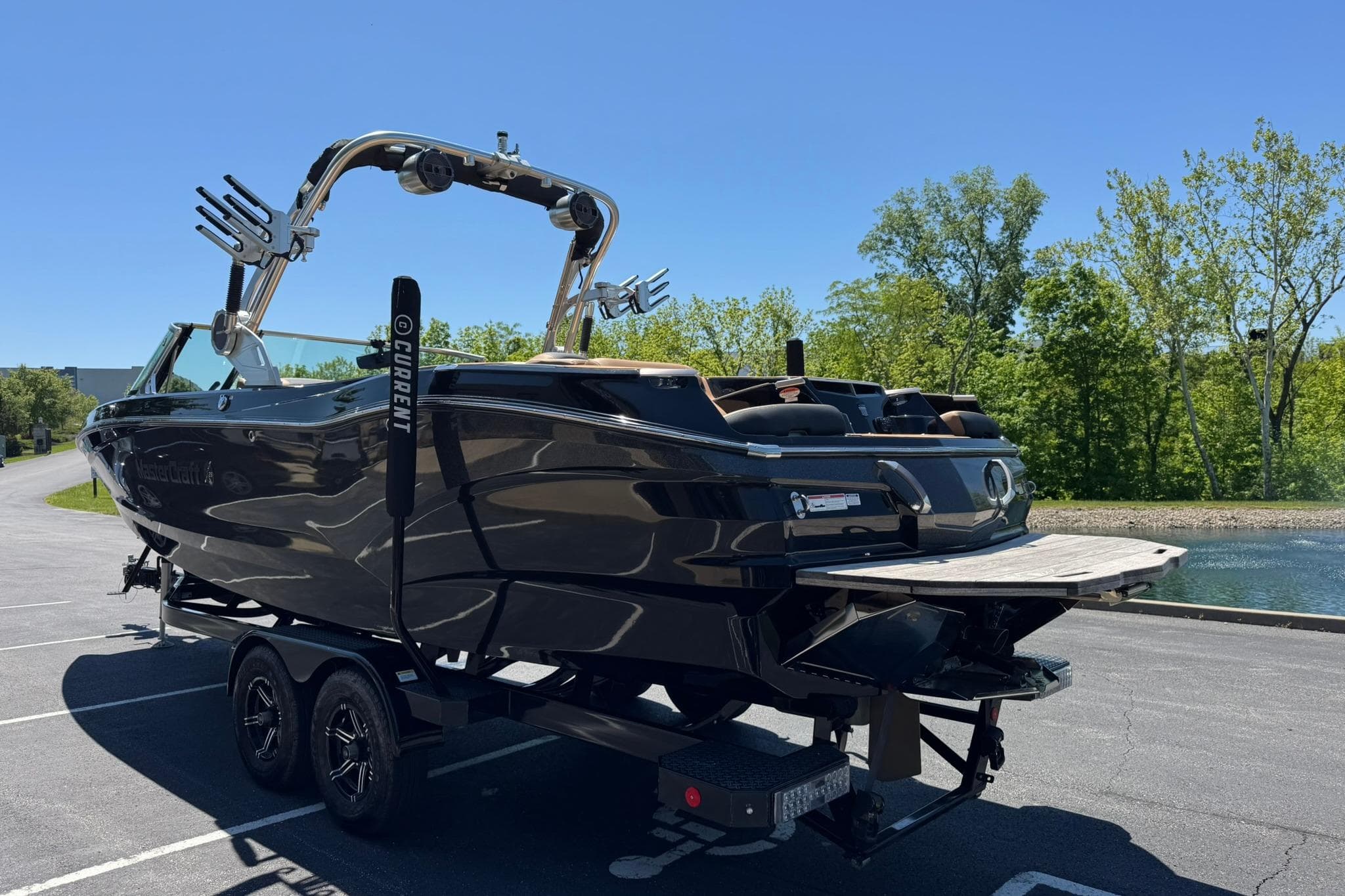 2021 MasterCraft X26 boat on trailer, parked near a scenic lake.