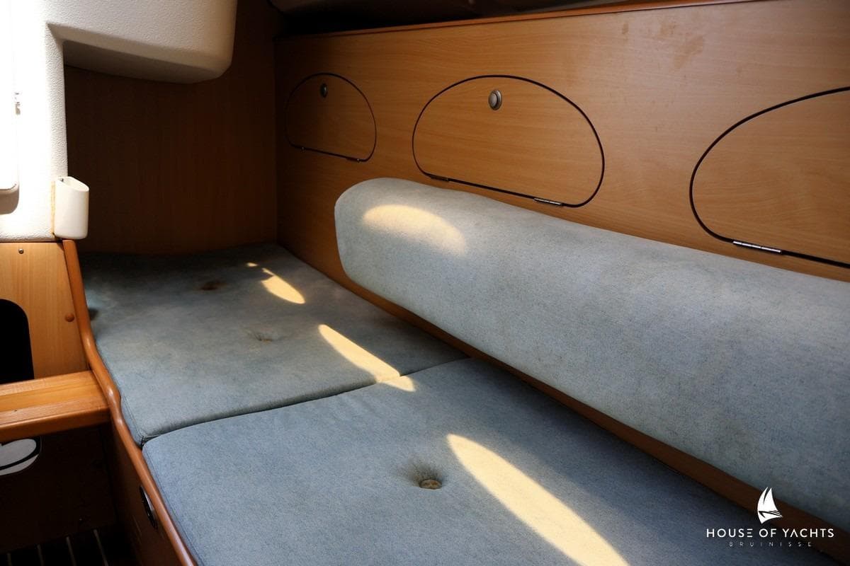 Interior cabin of a 2000 Etap 24i yacht with cushioned seating and wooden storage.