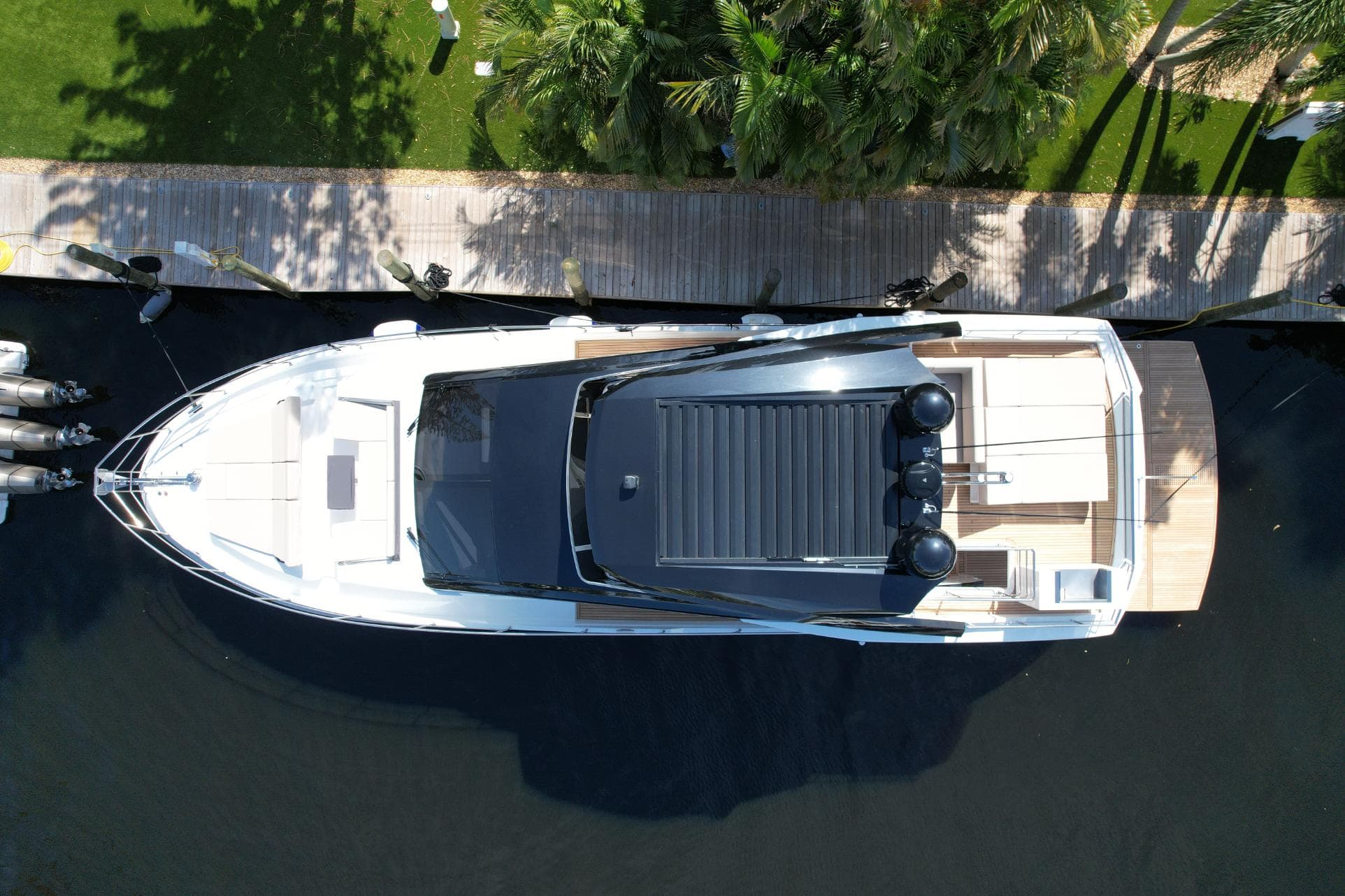 Top view of 2024 Astondoa 66 Flybridge yacht docked by a wooden pier.