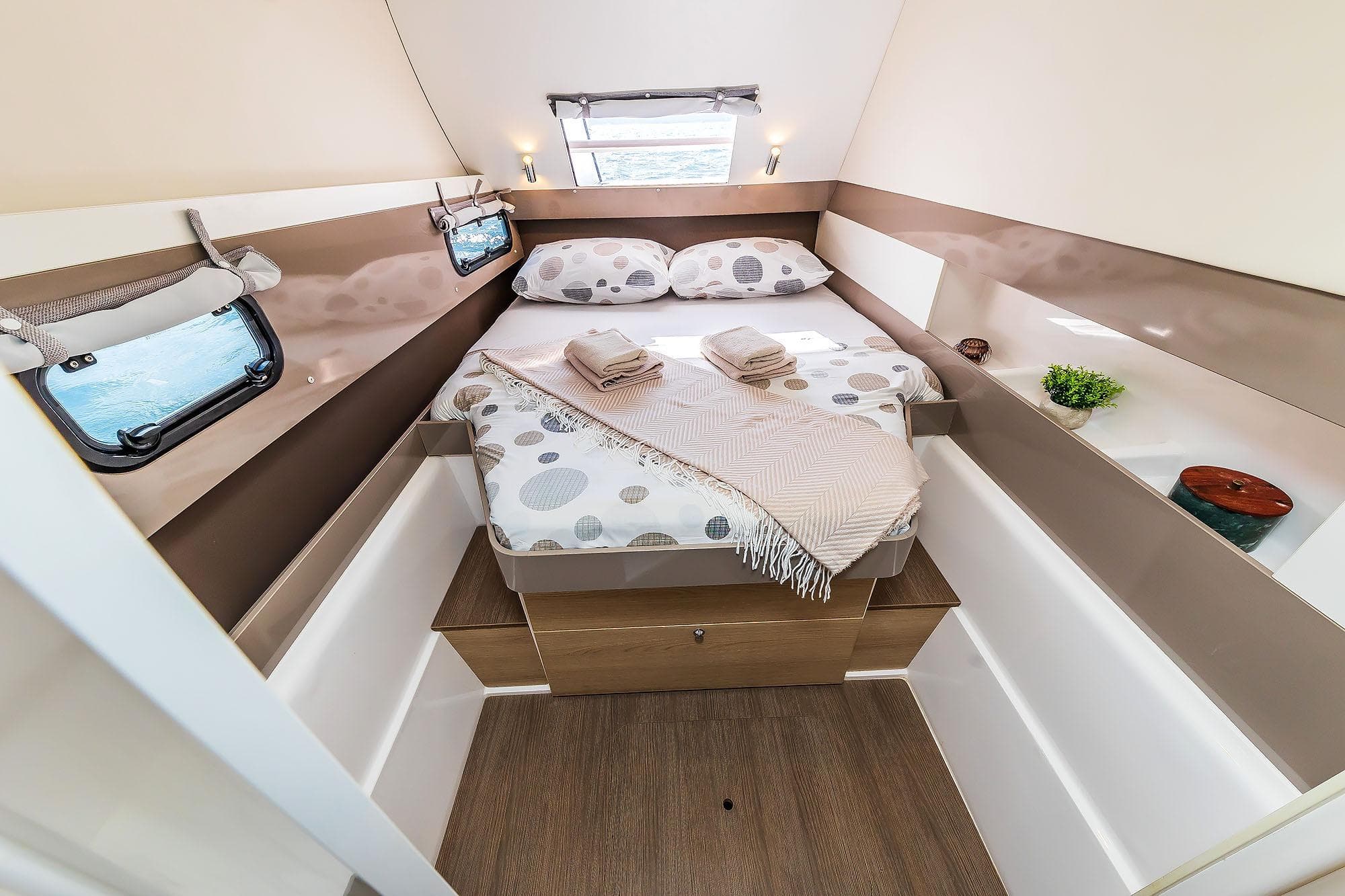 Cozy cabin interior of 2018 Bali 4.1 yacht with bed, windows, and decor.