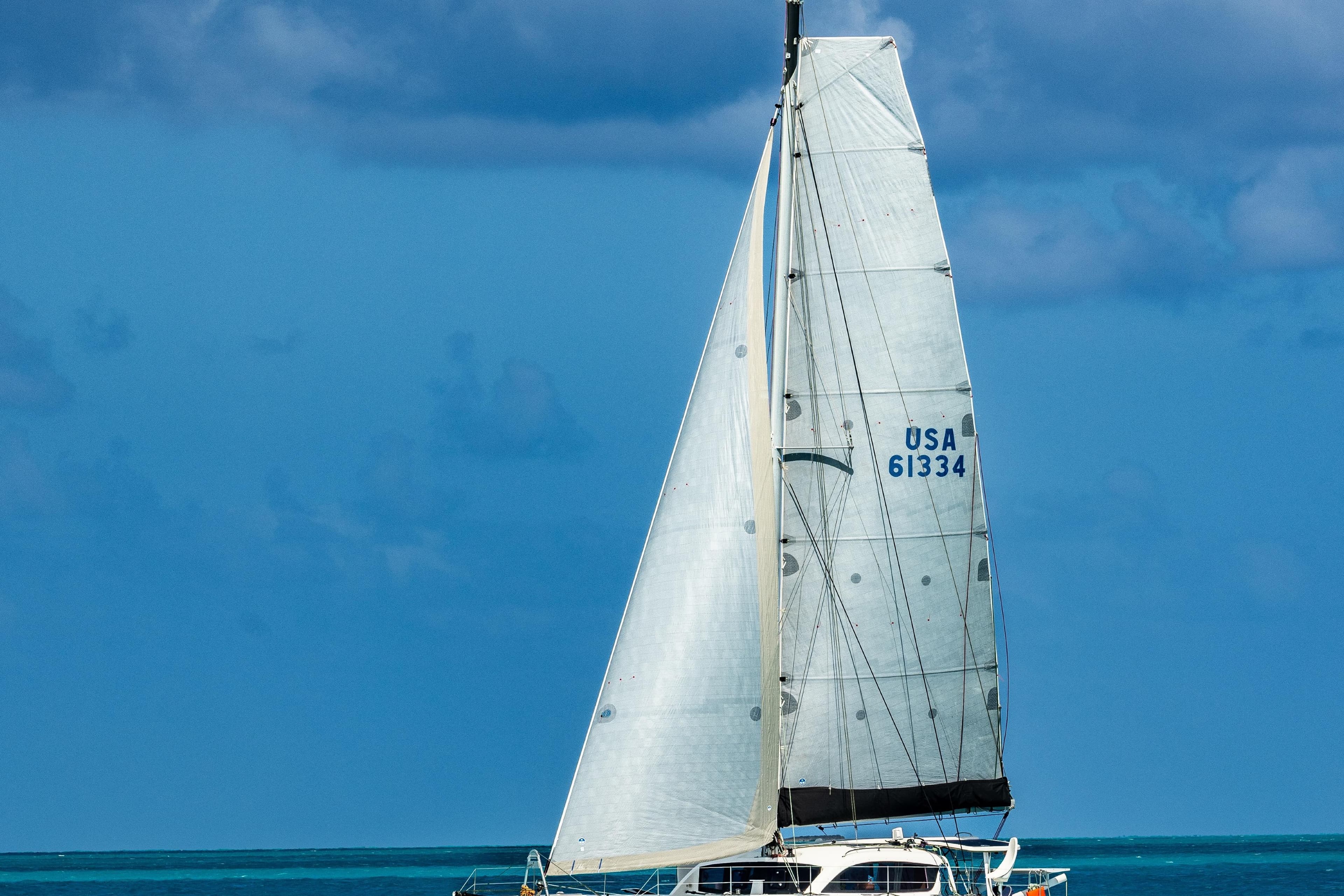 Sailing catamaran Outremer 45, 2016 model, gliding on blue ocean waters.
