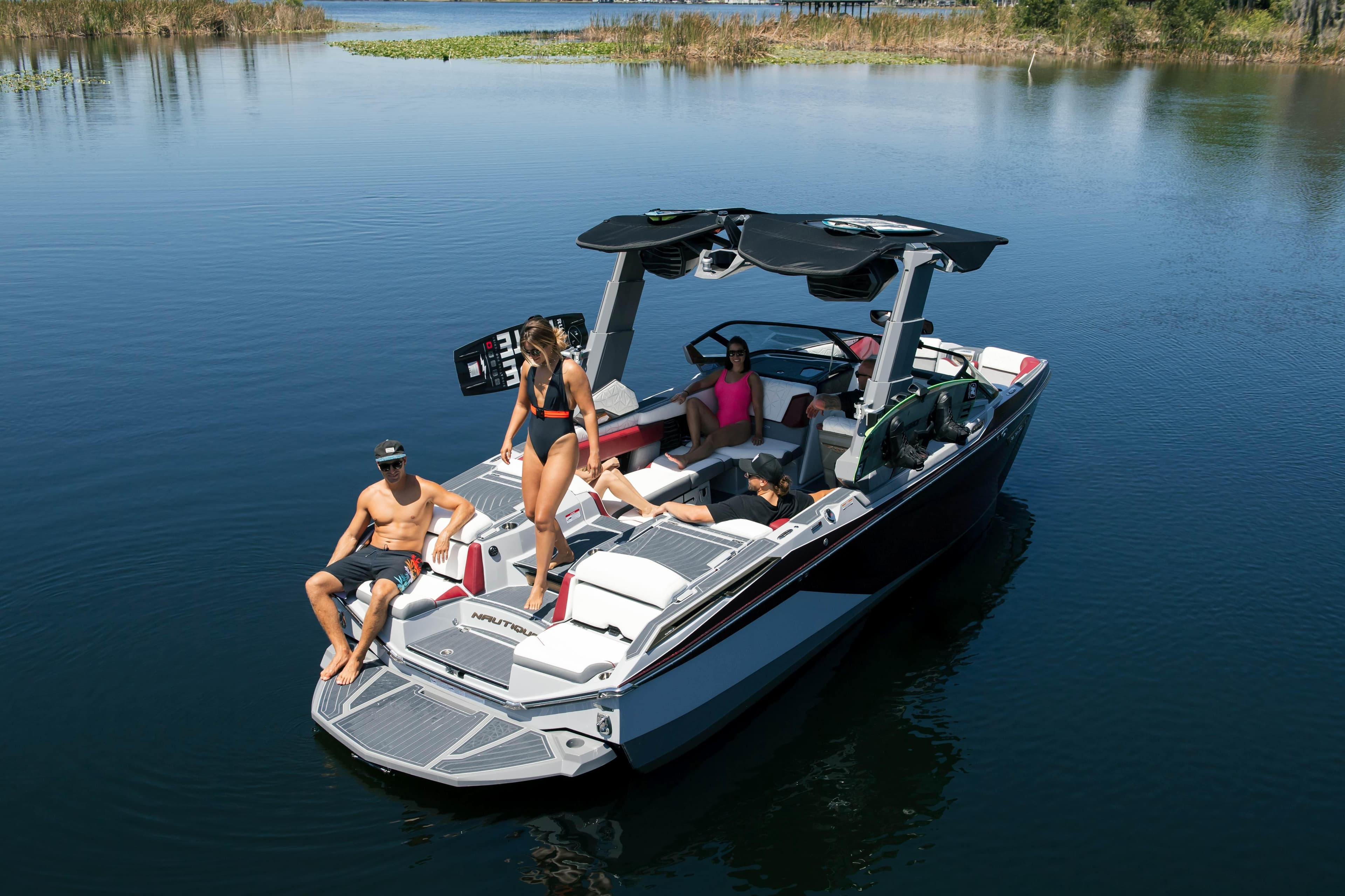 Nautique G23 PARAGON MY2026 boat with people relaxing on a calm lake.