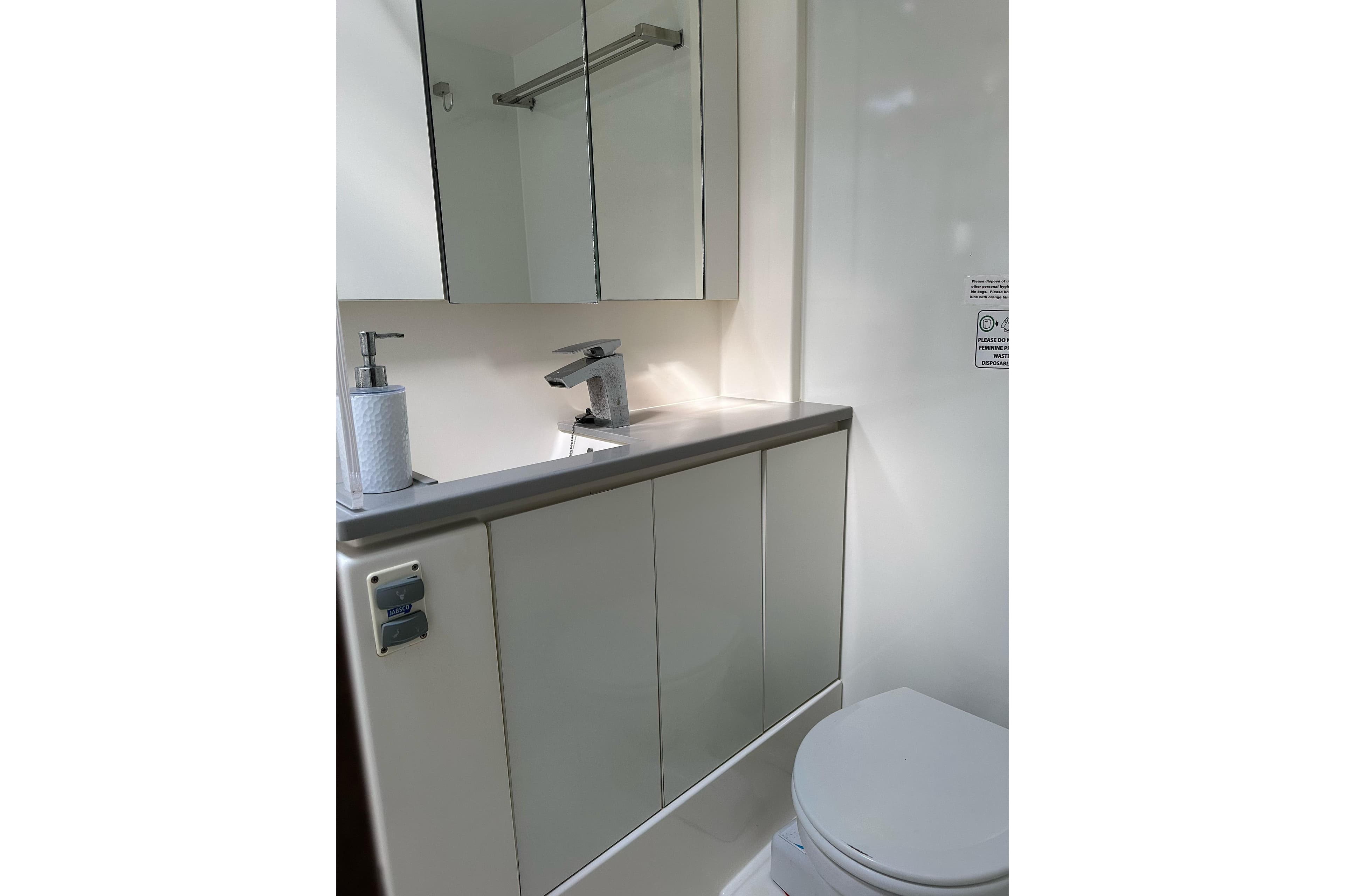 Modern bathroom in 2018 Leopard 45 yacht with sleek fixtures and mirrored cabinet.