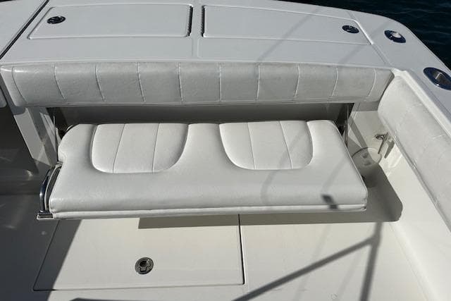 2015 Regulator 34 boat with white cushioned seating and storage compartment.