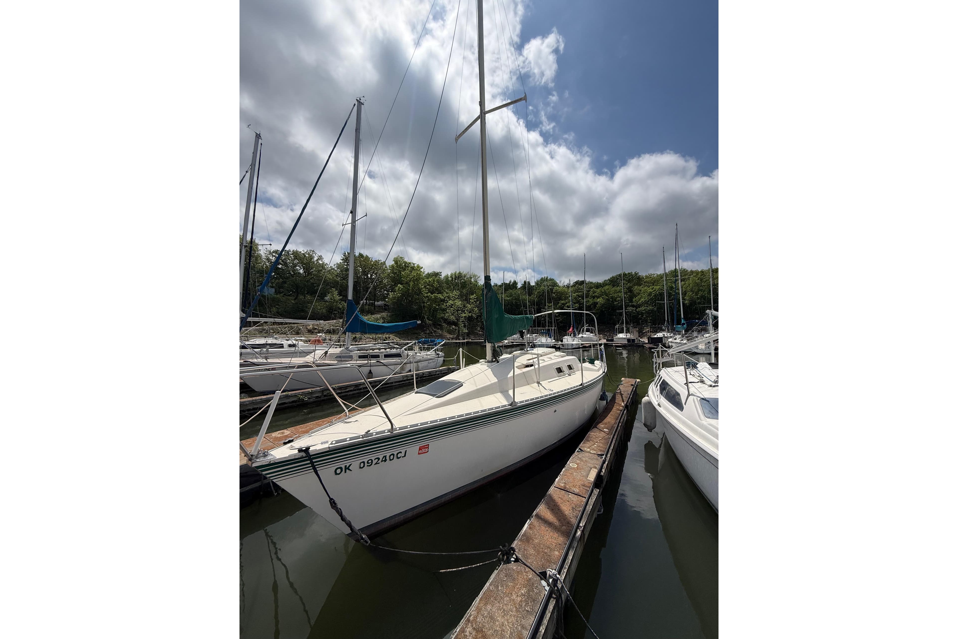 1985 Hunter 25.5 sailboat docked at a marina under cloudy skies.