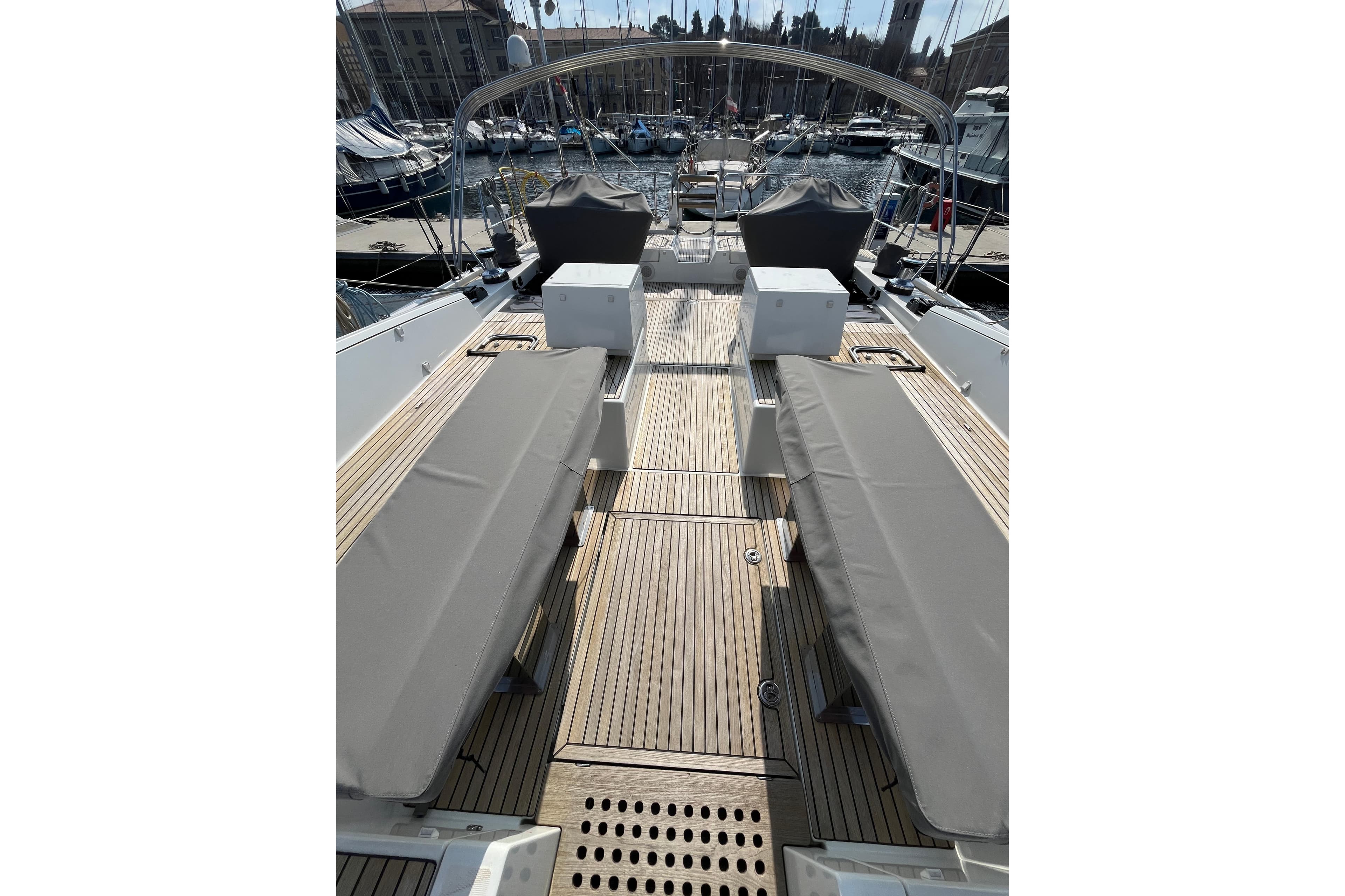 Luxurious Jeanneau 64 yacht deck, 2016 model, featuring sleek seating and elegant wood finish.