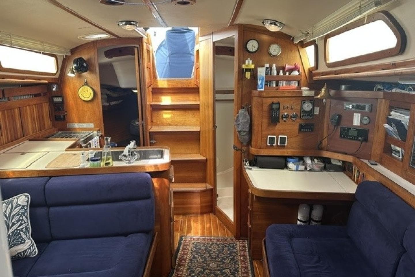 Interior of a 1994 Sabre 362 sailboat with wooden cabinetry and blue seating.