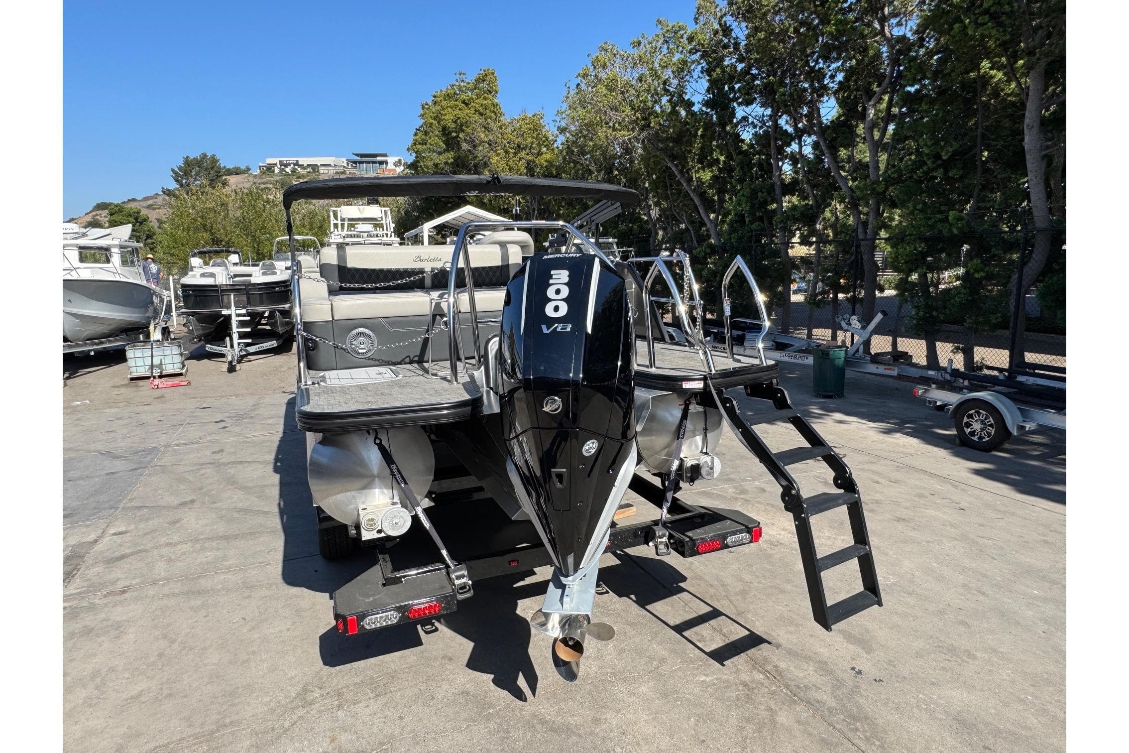 2026 Barletta Lusso 23UC pontoon boat with powerful 300 V8 engine, docked outdoors.