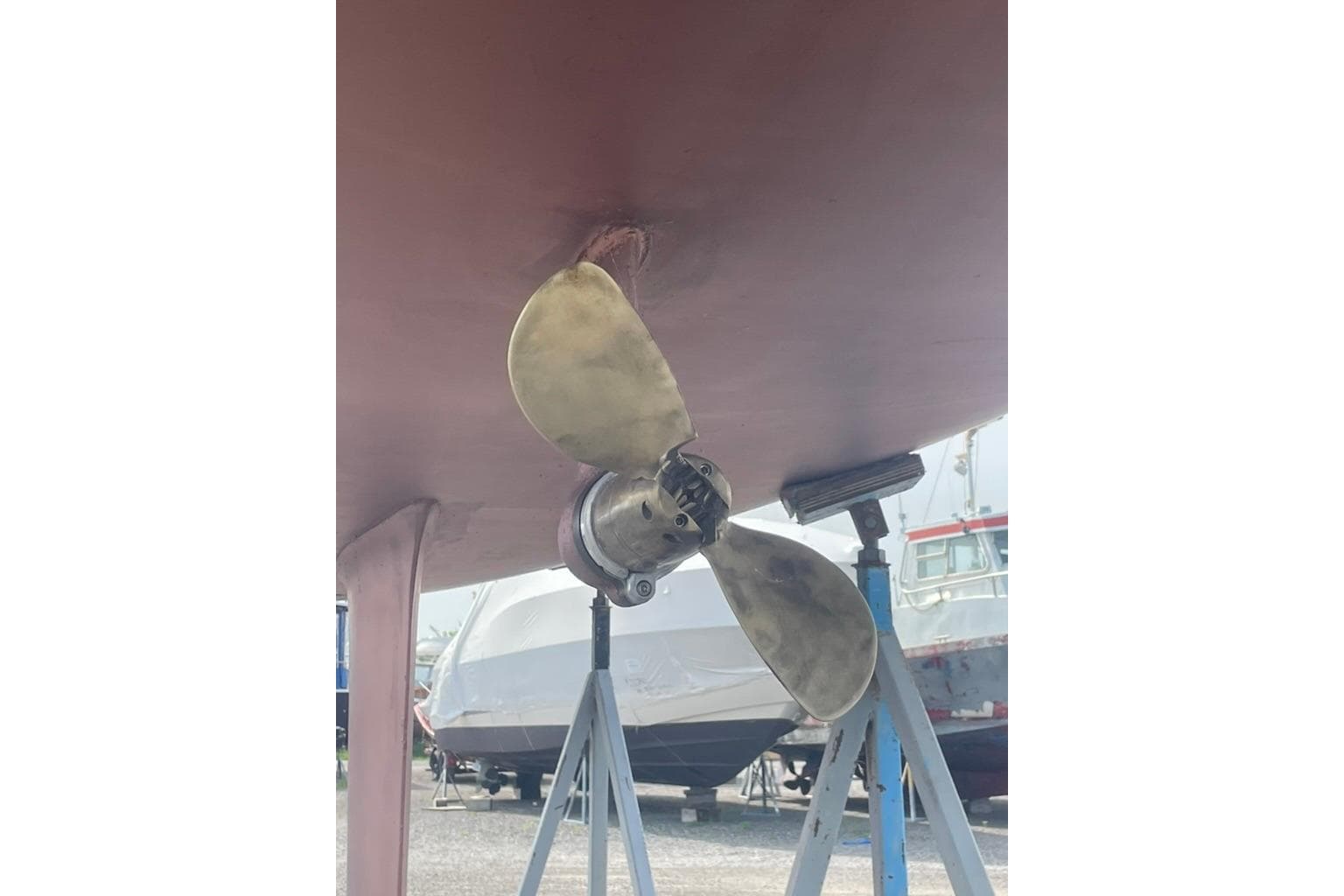 Propeller of 2008 Beneteau First 10R sailboat on stands in a boatyard.