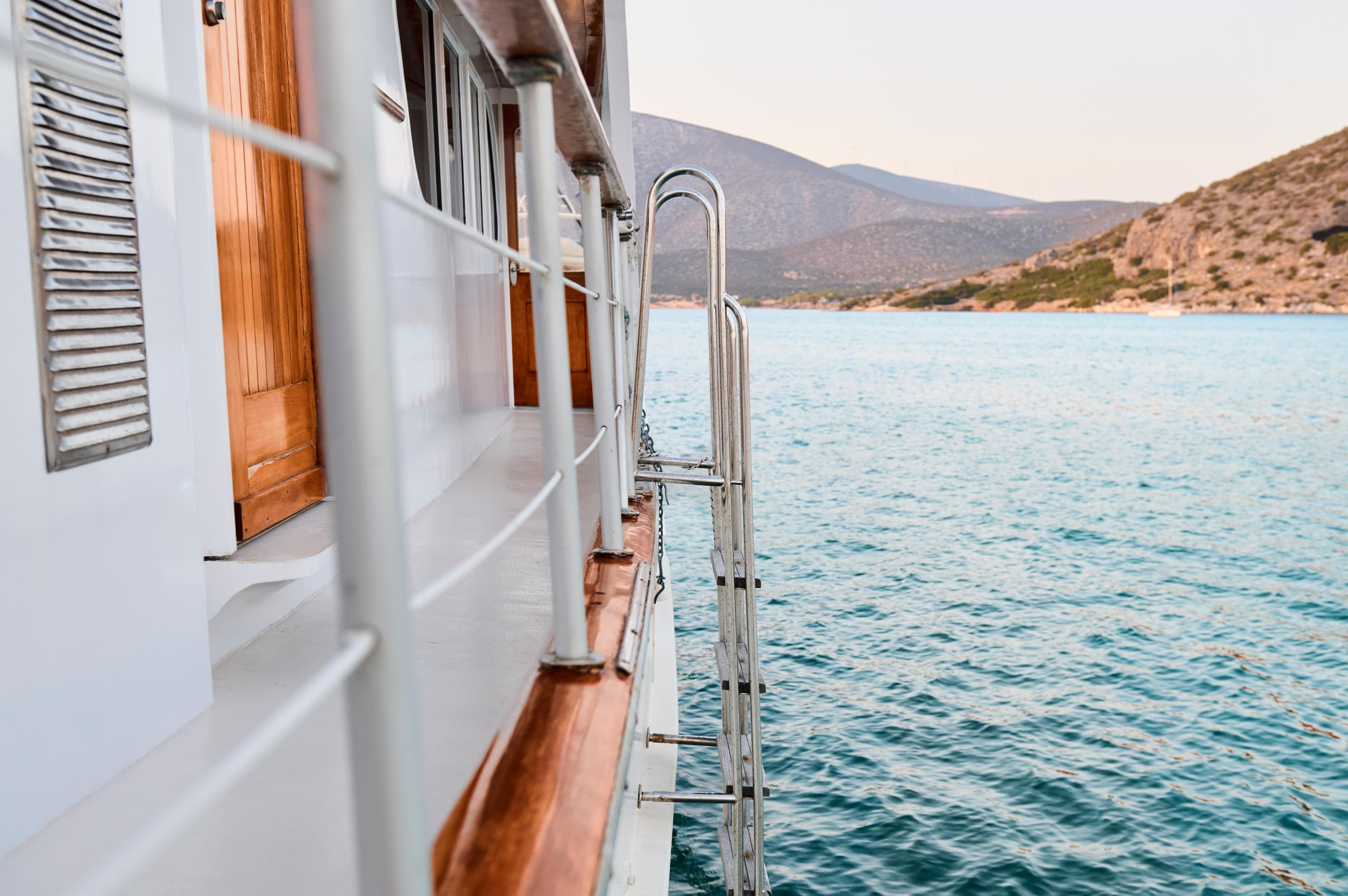 Side view of a 1960 Burger 85 yacht on calm blue water.