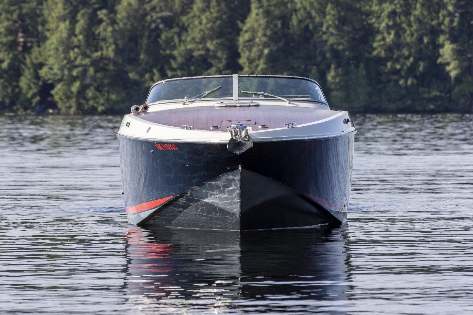 Front view of a 1997 Kavalk 30 boat on a calm lake.