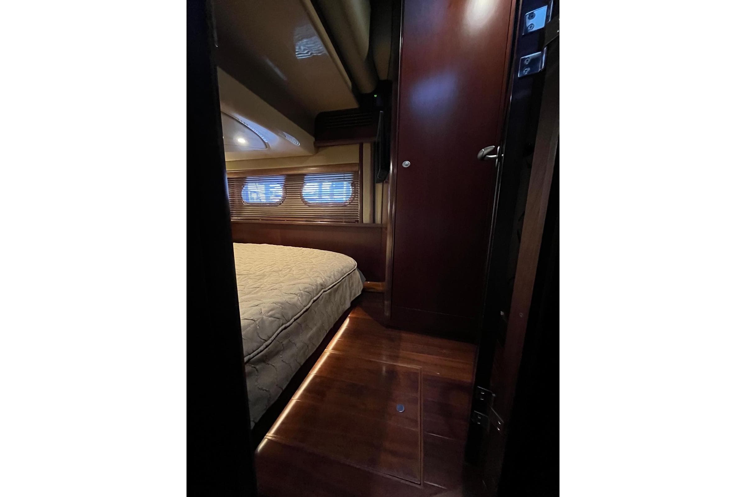 Interior cabin of 2006 Sea Ray 52 Sedan Bridge with wooden flooring and bed.