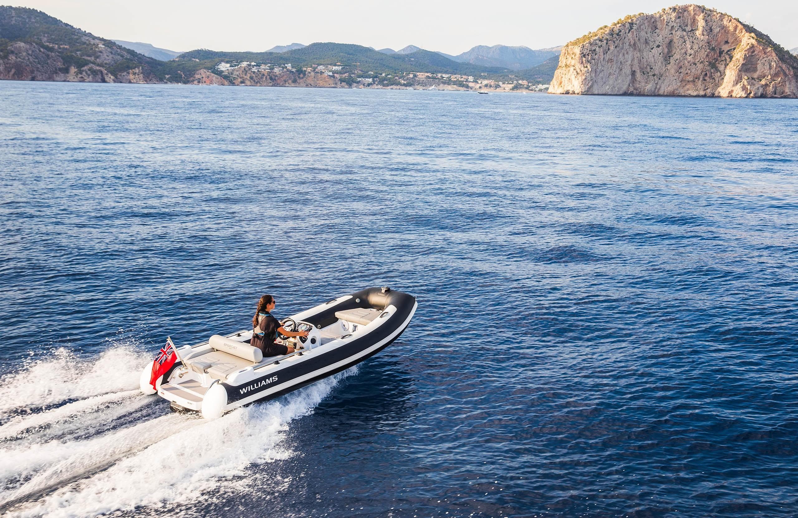 2025 Williams Jet Tenders Sportjet 435 cruising on open water near rocky coastline.