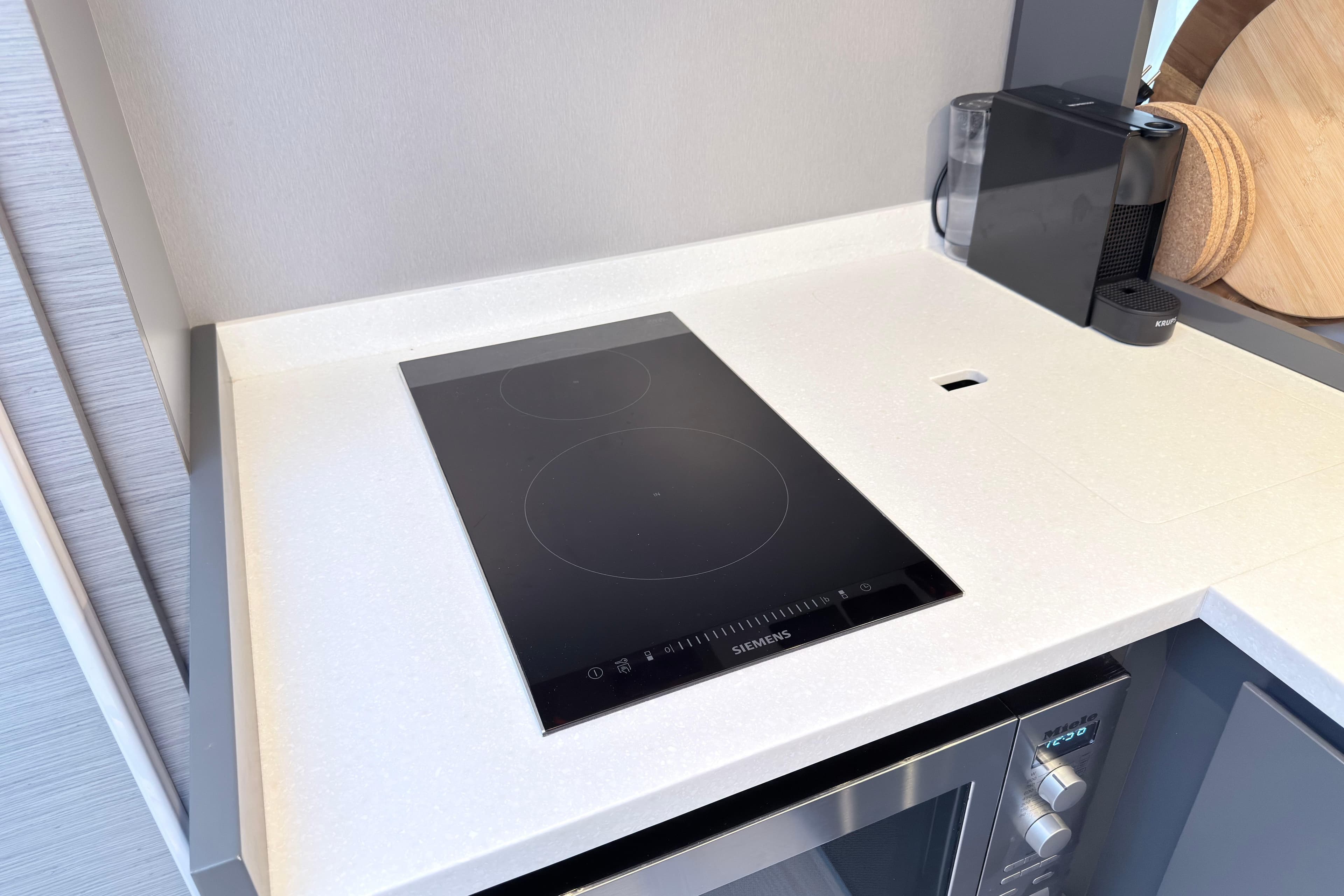 Modern kitchen with Siemens induction cooktop and appliances on a sleek countertop.