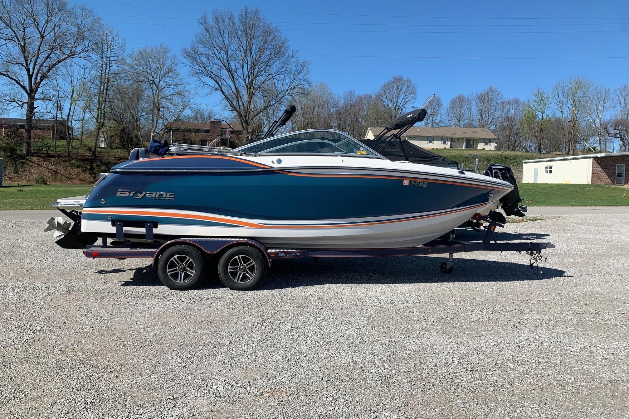 2015 Bryant Calandra boat on trailer, parked outdoors on gravel surface.