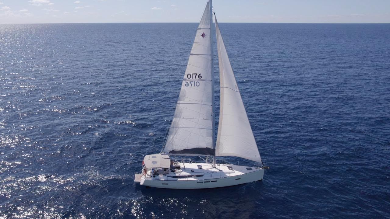 2015 Jeanneau Sun Odyssey 509 sailing on open ocean under clear skies.