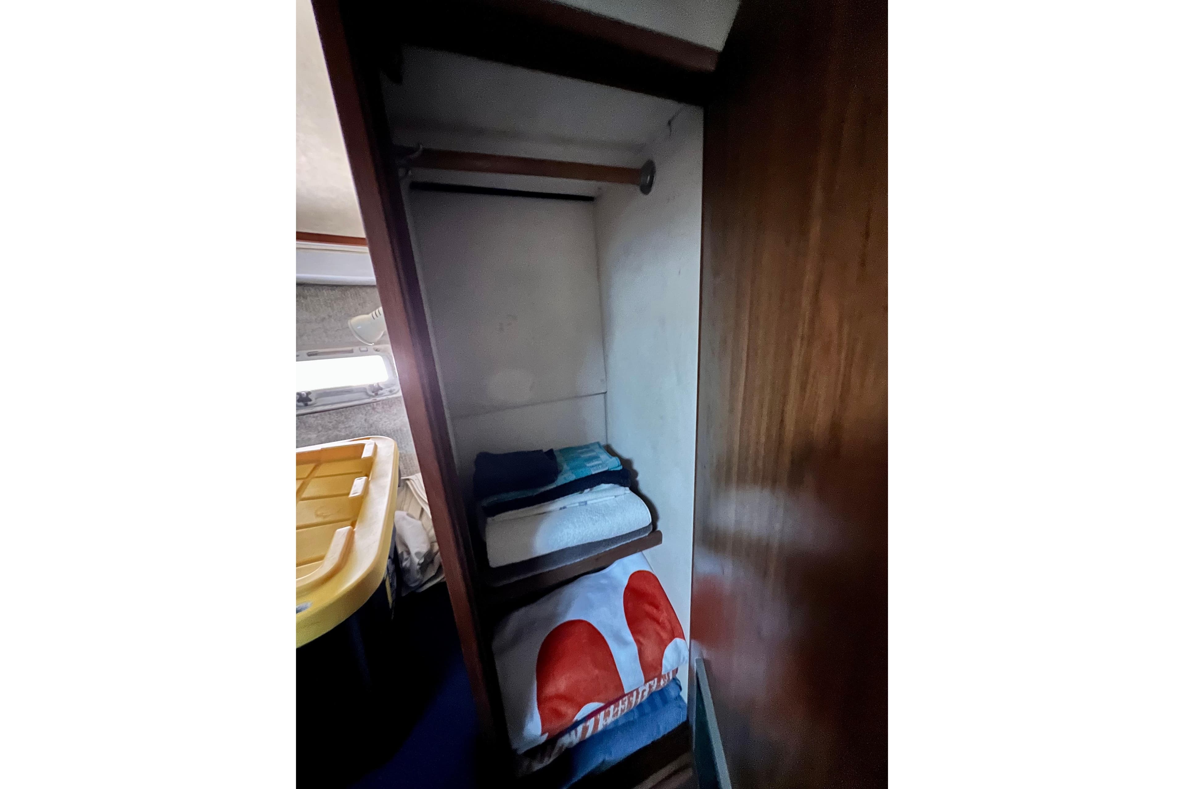 Interior of 1982 Bertram 46 Convertible yacht with storage shelves and towels.