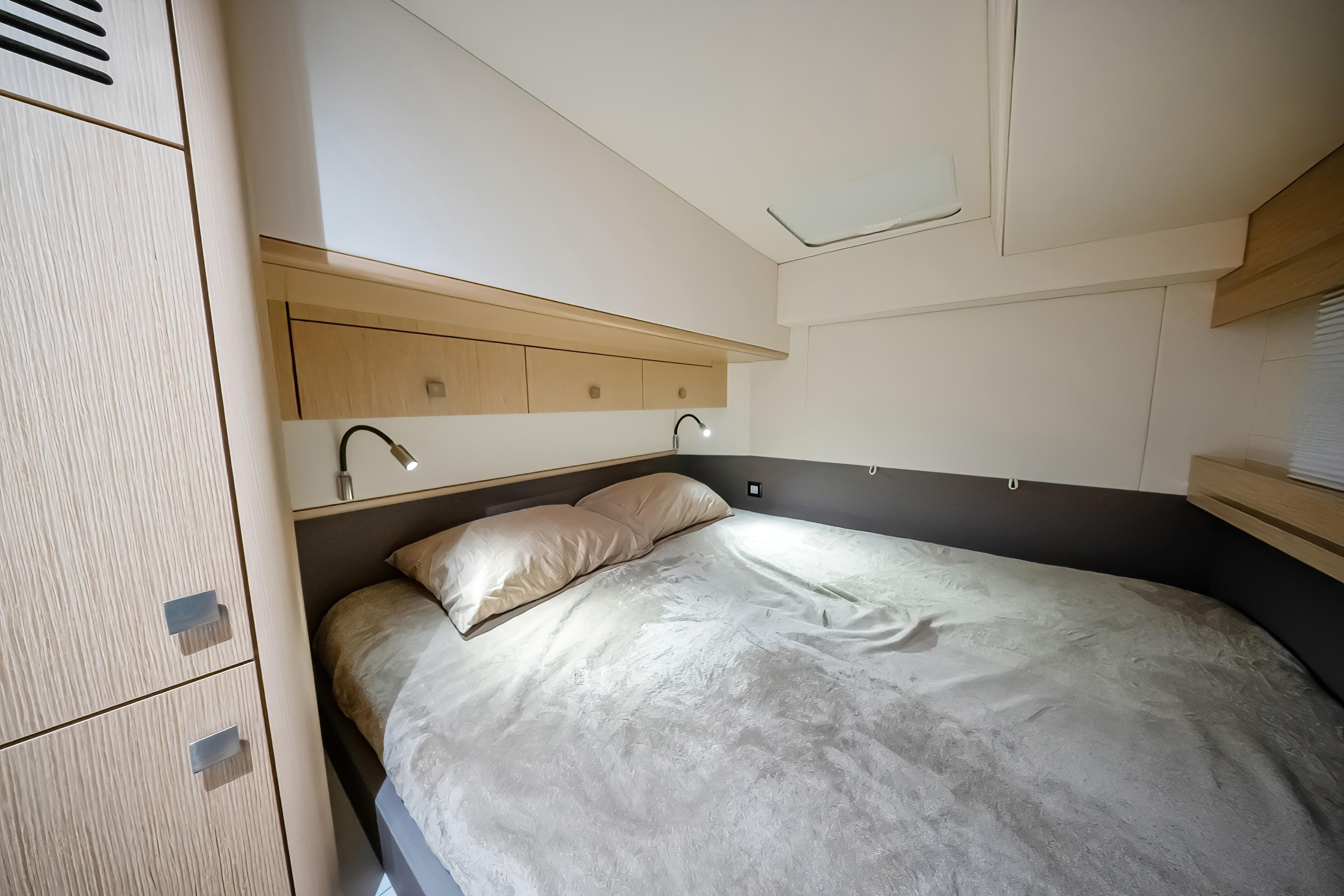 Luxurious bedroom interior of 2023 Privilege 510 yacht with modern design and cozy bedding.