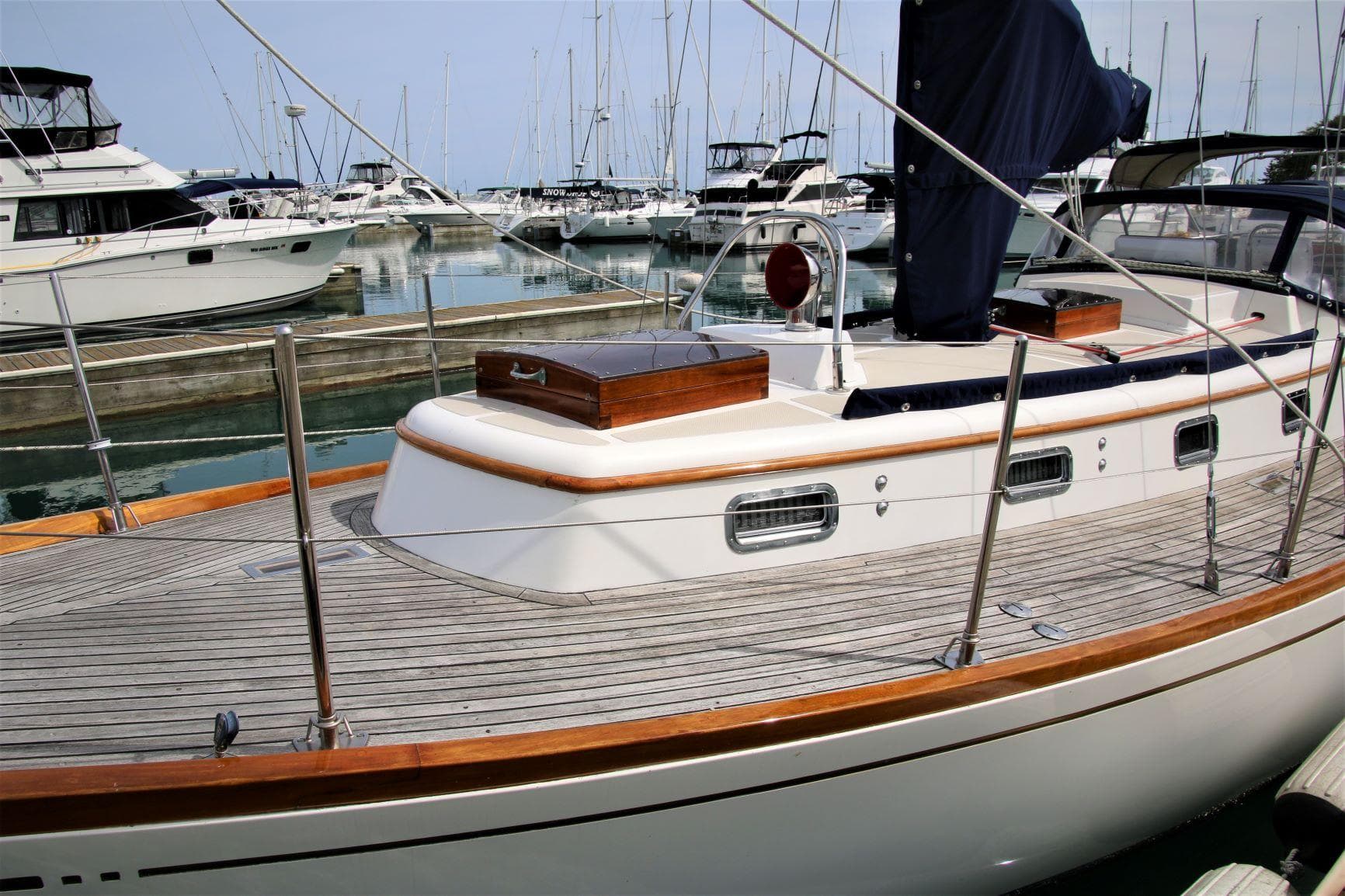 Sailboat in marina, Mason 33 model, 1986, with wooden deck and sleek design.