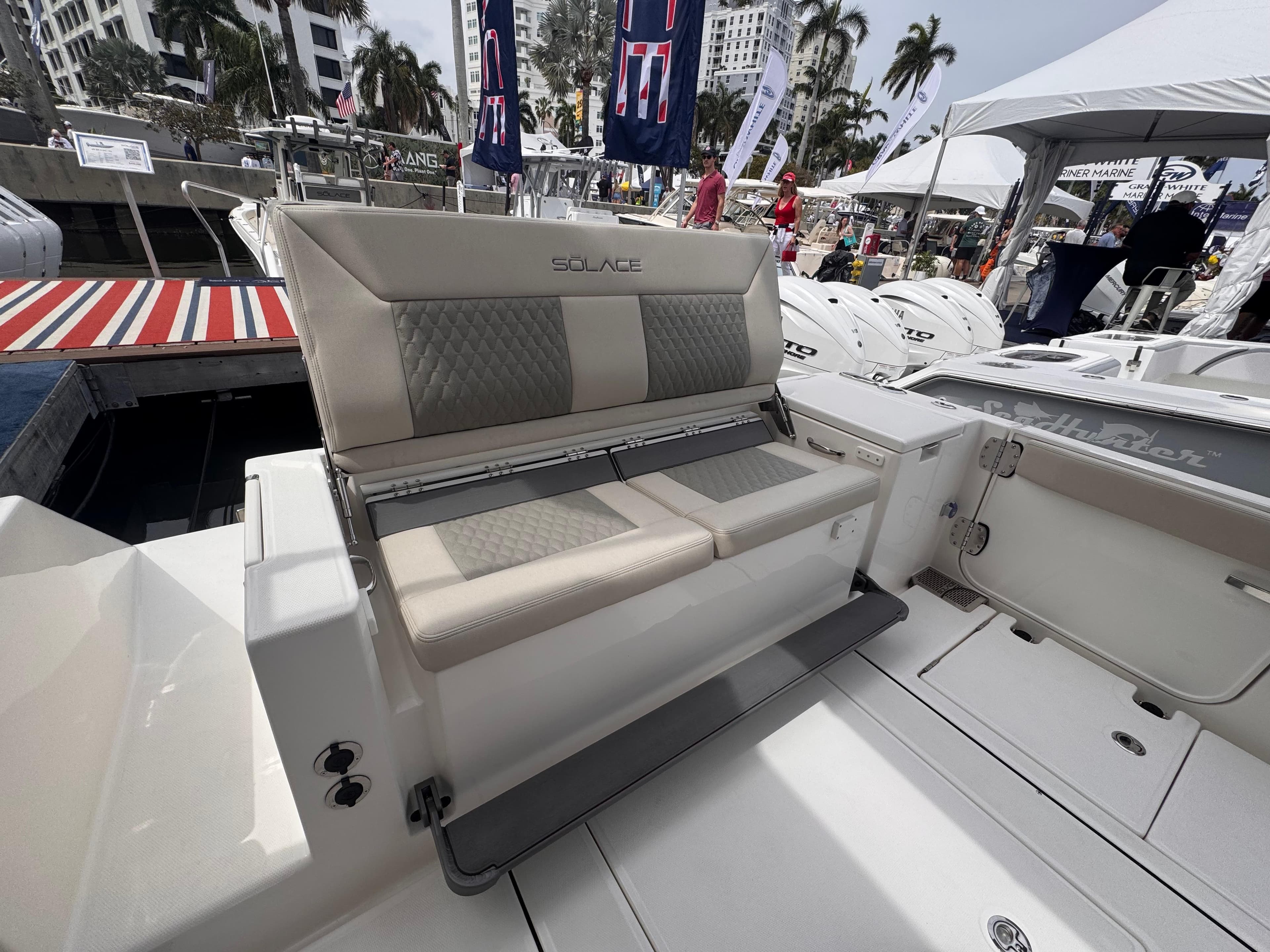 Luxury seating on 2025 Solace 30 CS boat, showcased at a marina event.