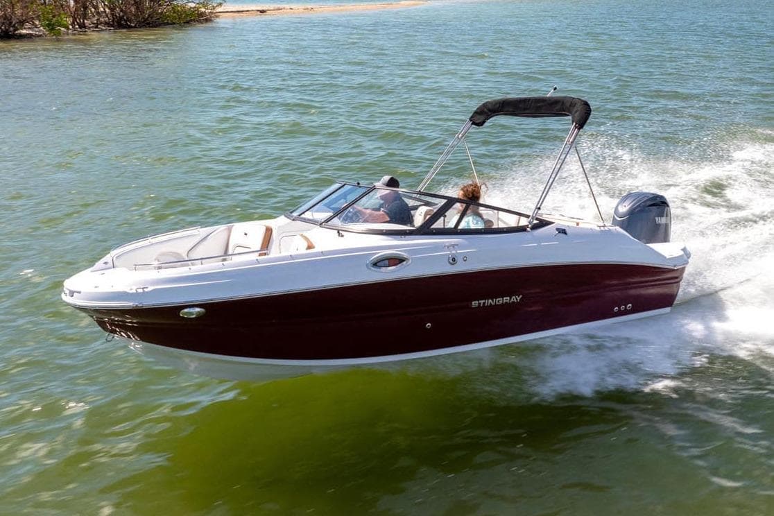 Manufacturer Provided Image: 2026 Stingray 211 DC boat cruising on a sunny lake.