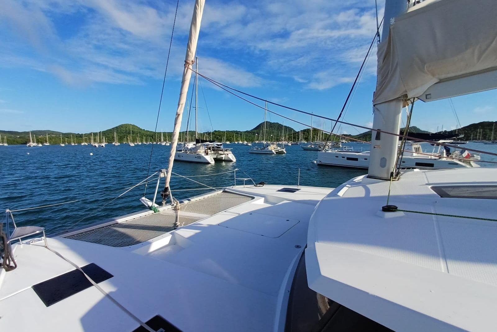2018 Fountaine Pajot Saona 47 catamaran on serene blue waters with distant sailboats.
