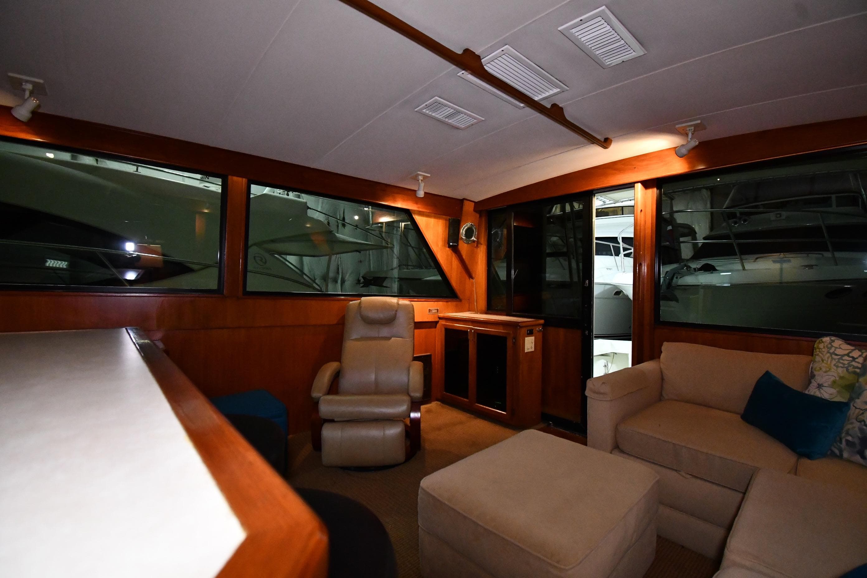 Interior of 1988 Viking 48 Convertible yacht with cozy seating and large windows.