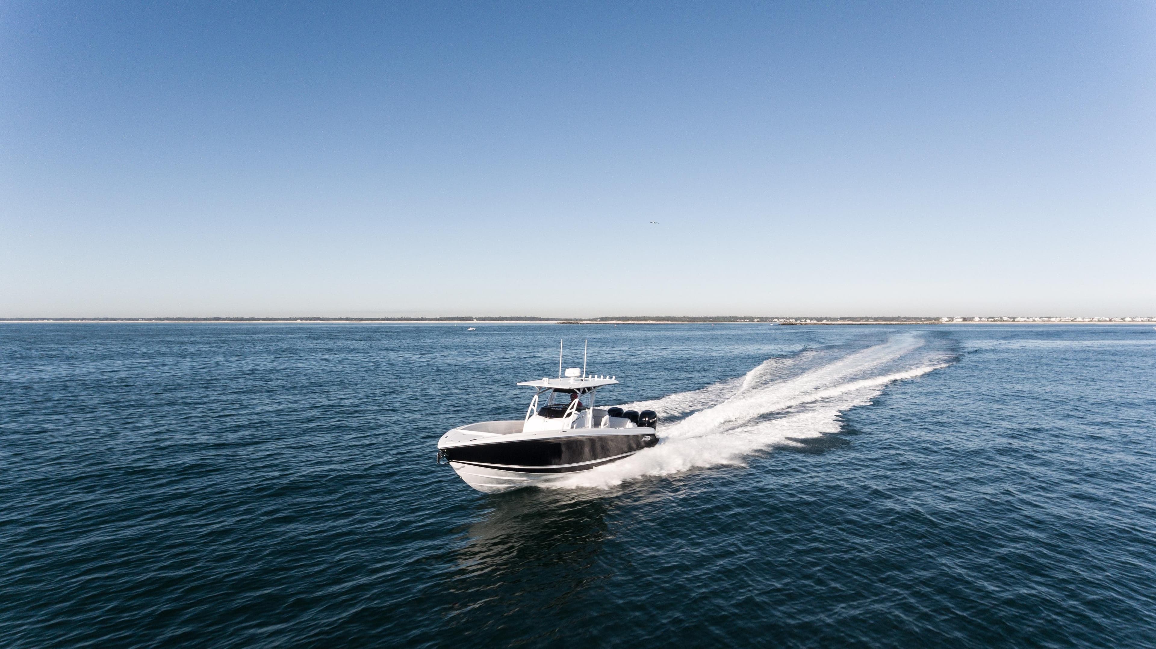 2025 Nor-Tech 340 boat cruising on open water under clear blue sky.