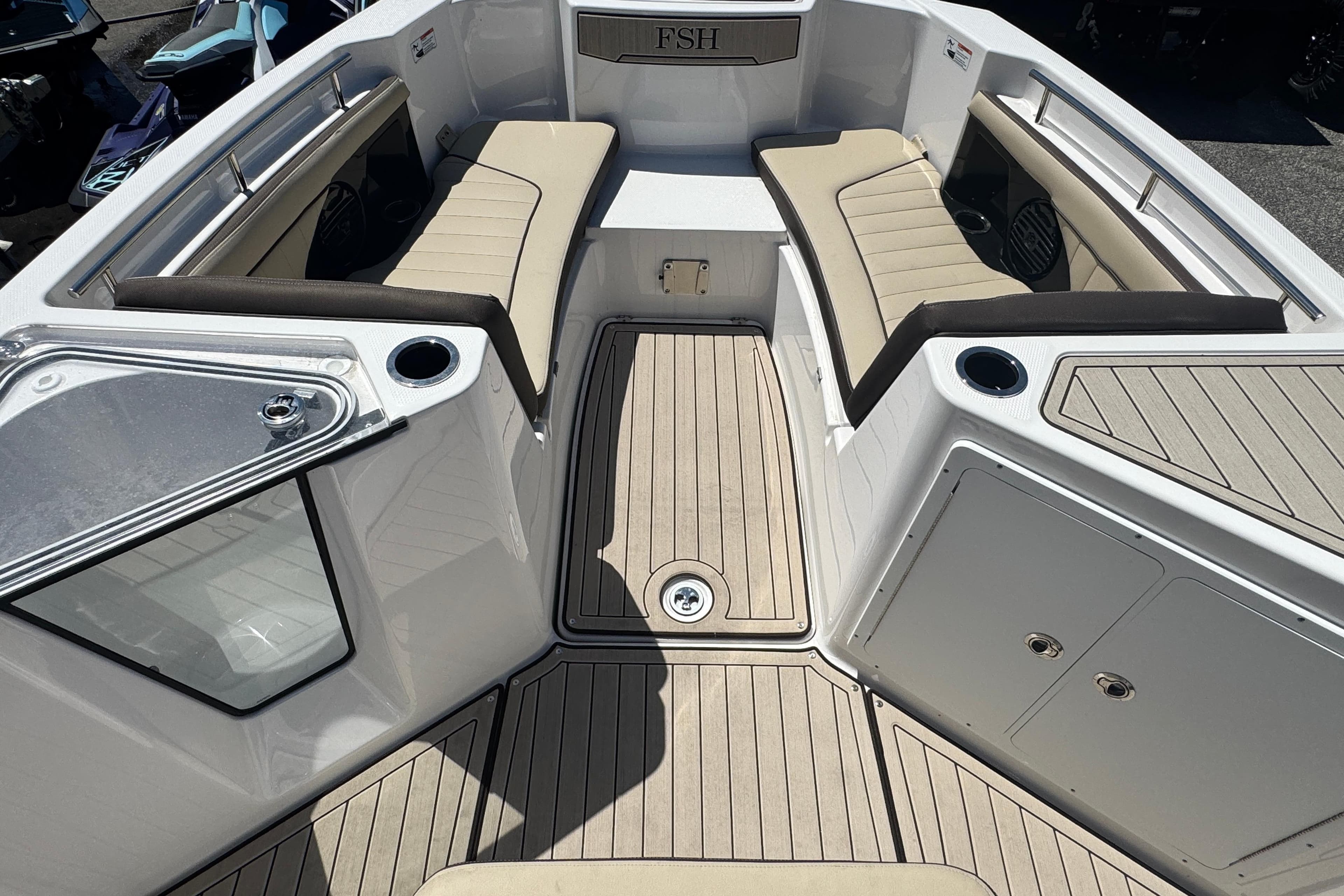 2026 Yamaha Boats 255 FSH Sport E interior with cushioned seating and storage compartments.