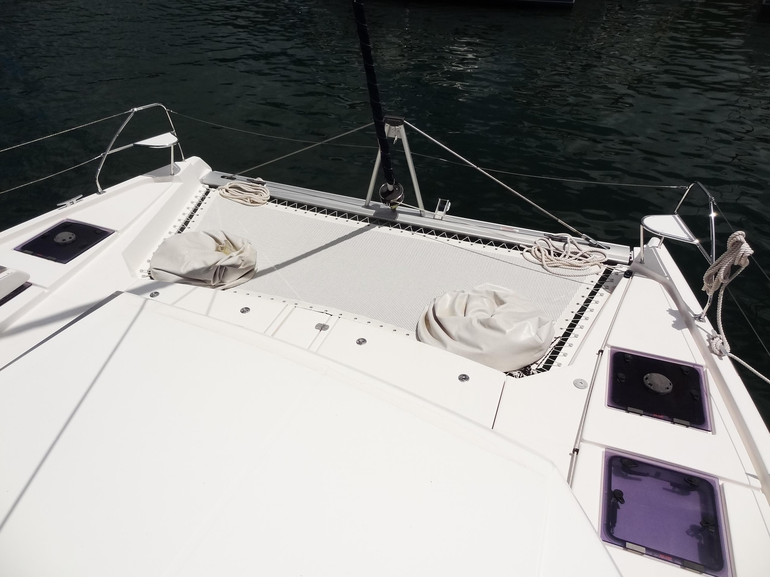 Leopard 45 catamaran deck, 2020 model, featuring netting and hatches on calm water.