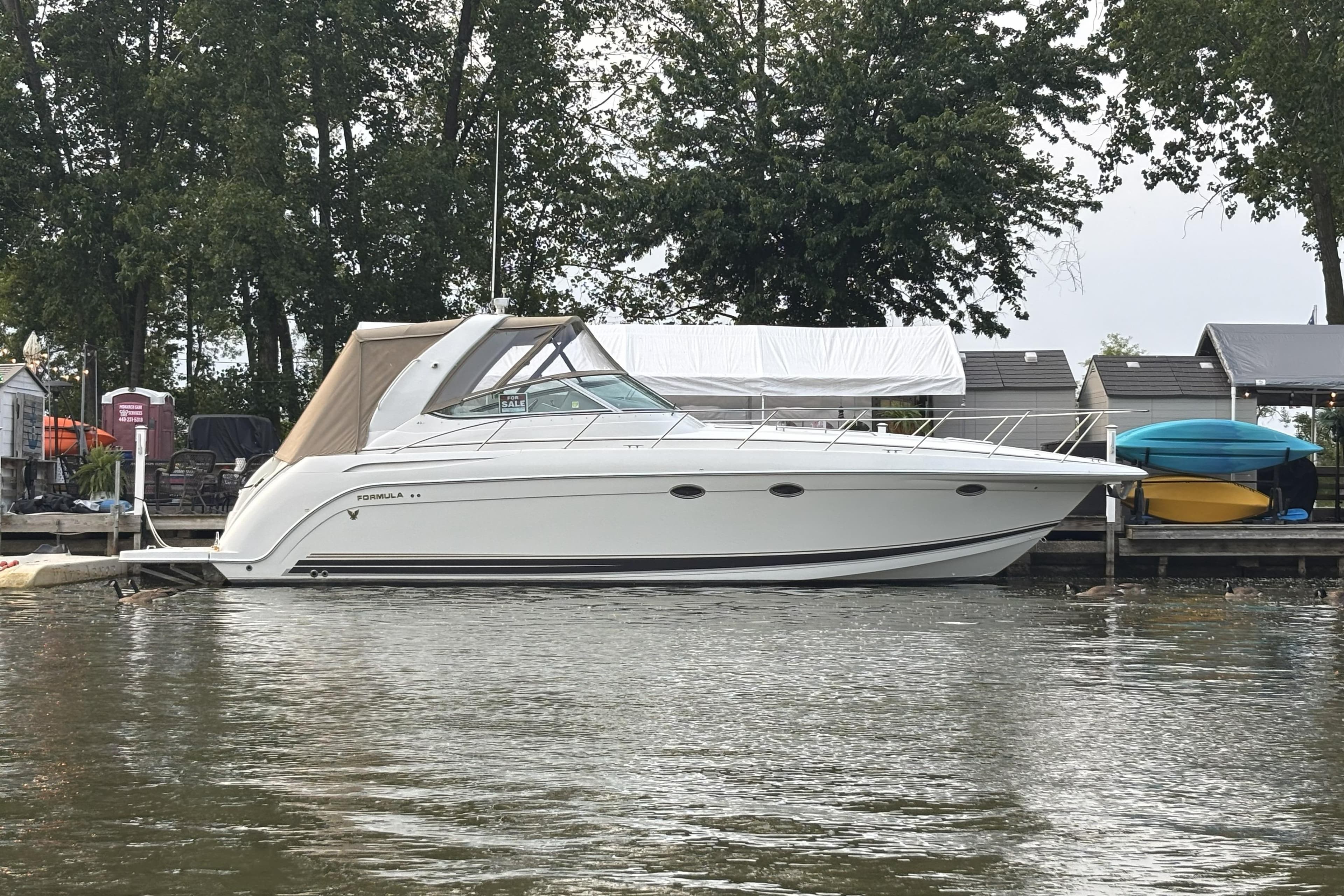 2001 Formula 37 Performance Cruiser docked by waterfront homes.
