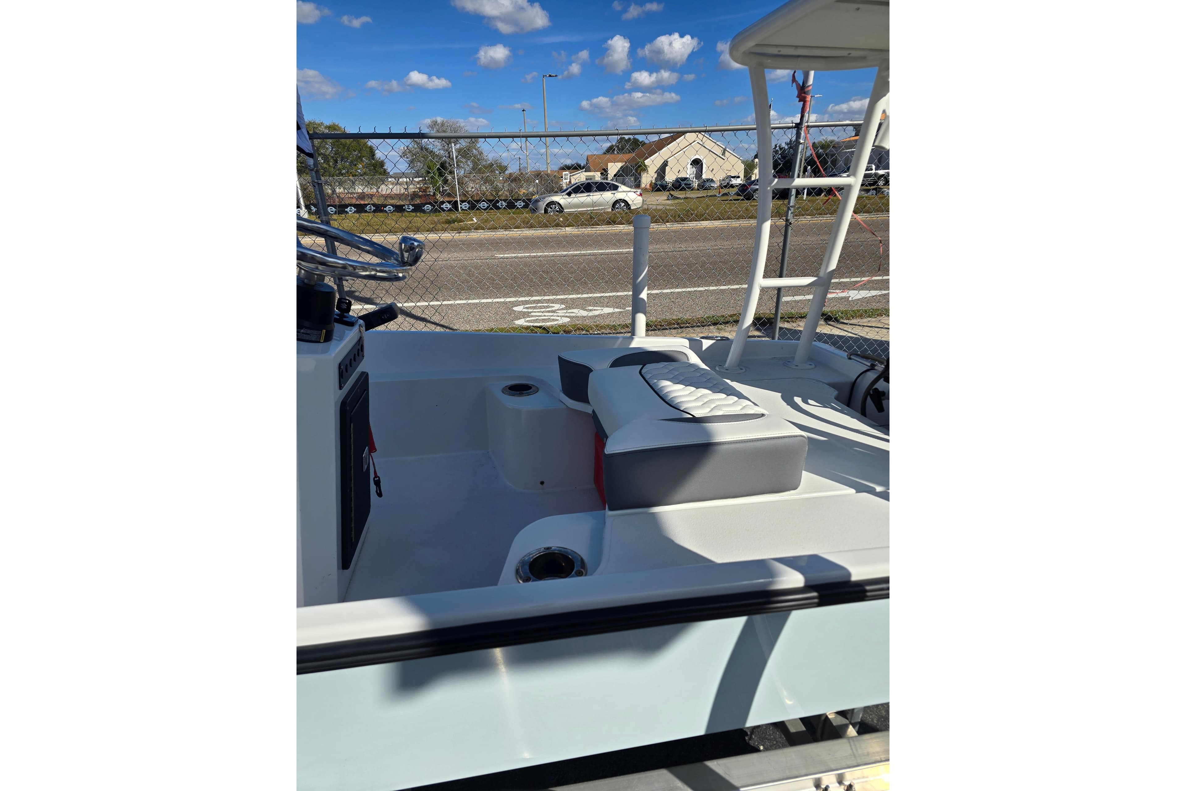 Custom XPC 16 boat interior, 2025 model, featuring seating and steering wheel under a clear blue sky.