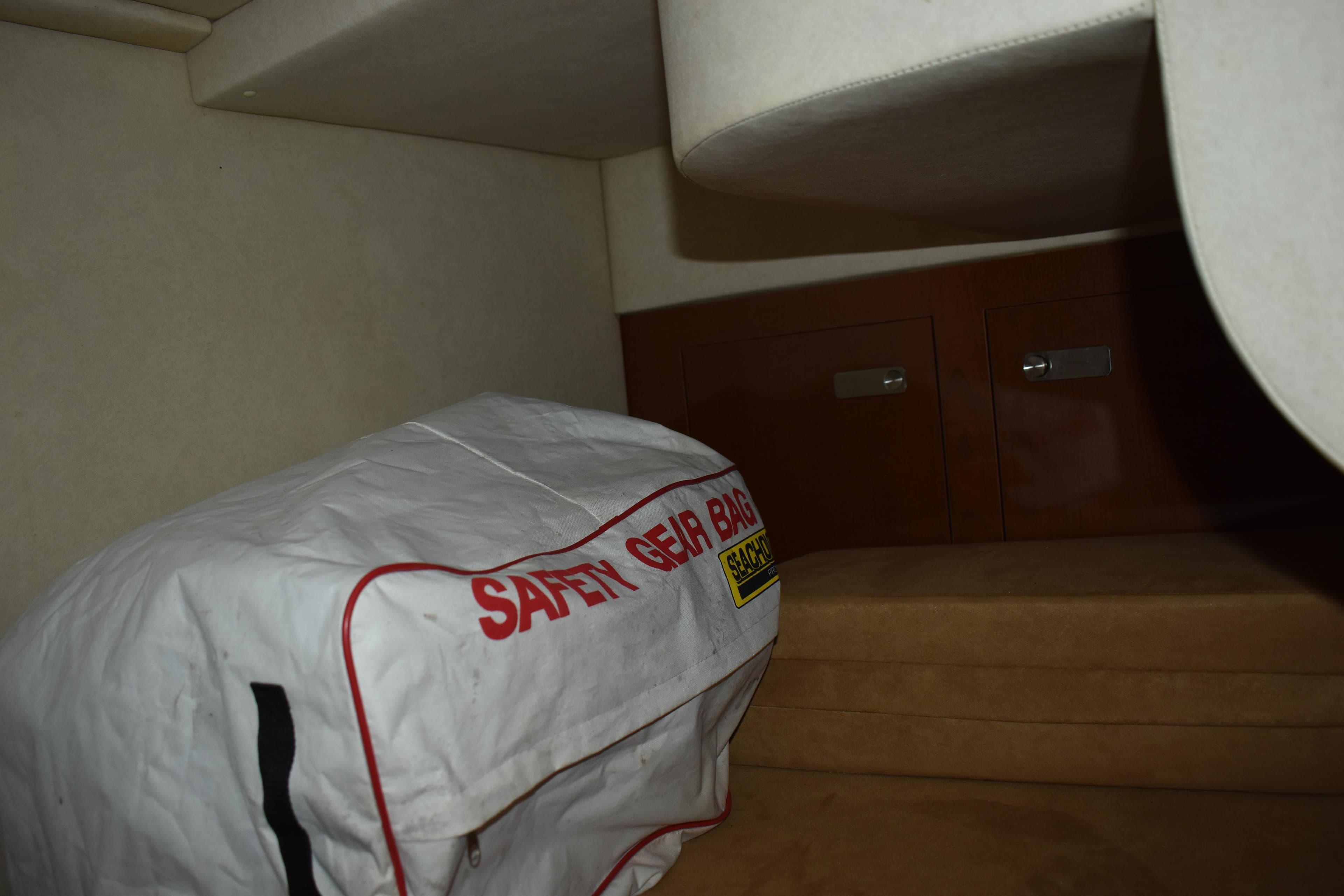 Interior of 2011 Sea Ray 310 Sundancer with safety gear bag and storage cabinets.