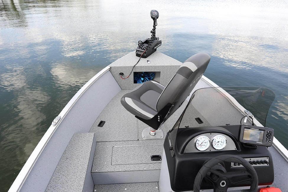 Manufacturer Provided Image: 2025 Lund 1600 Fury SS boat interior with steering console and seating on calm water.