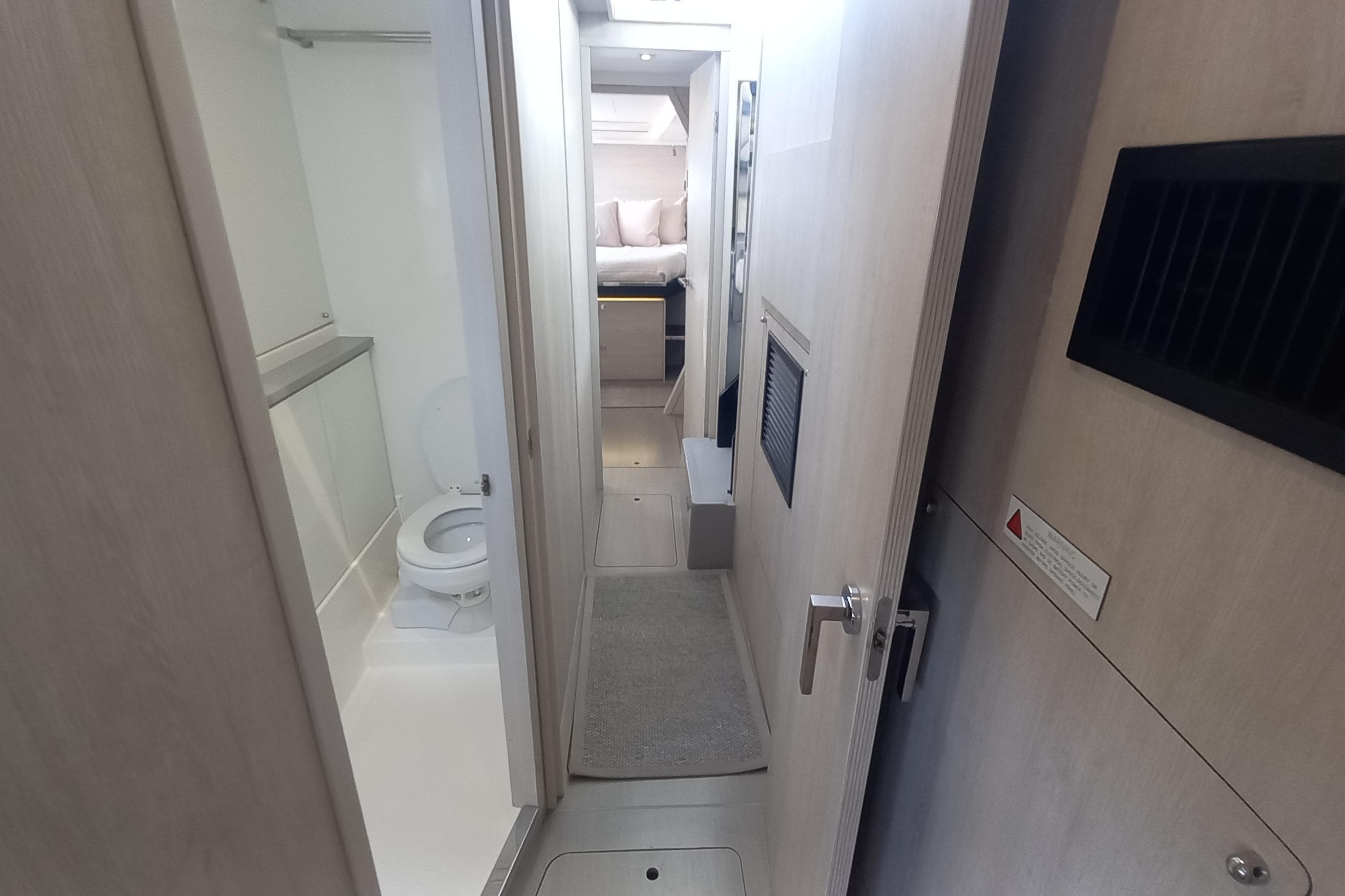 Interior of 2019 Leopard 45 yacht showing bathroom and hallway leading to bedroom.