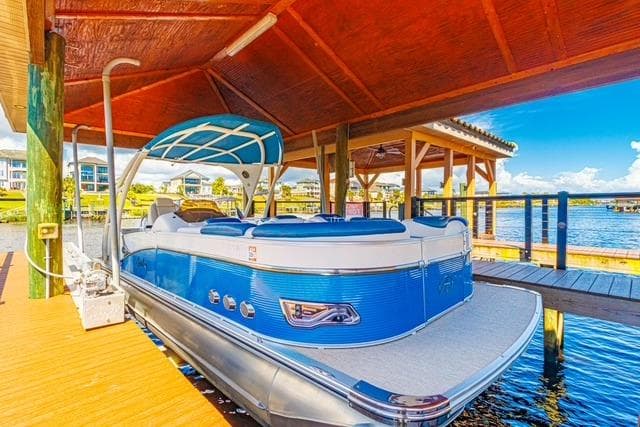 2020 Avalon Catalina 2585 pontoon boat docked under a wooden canopy.