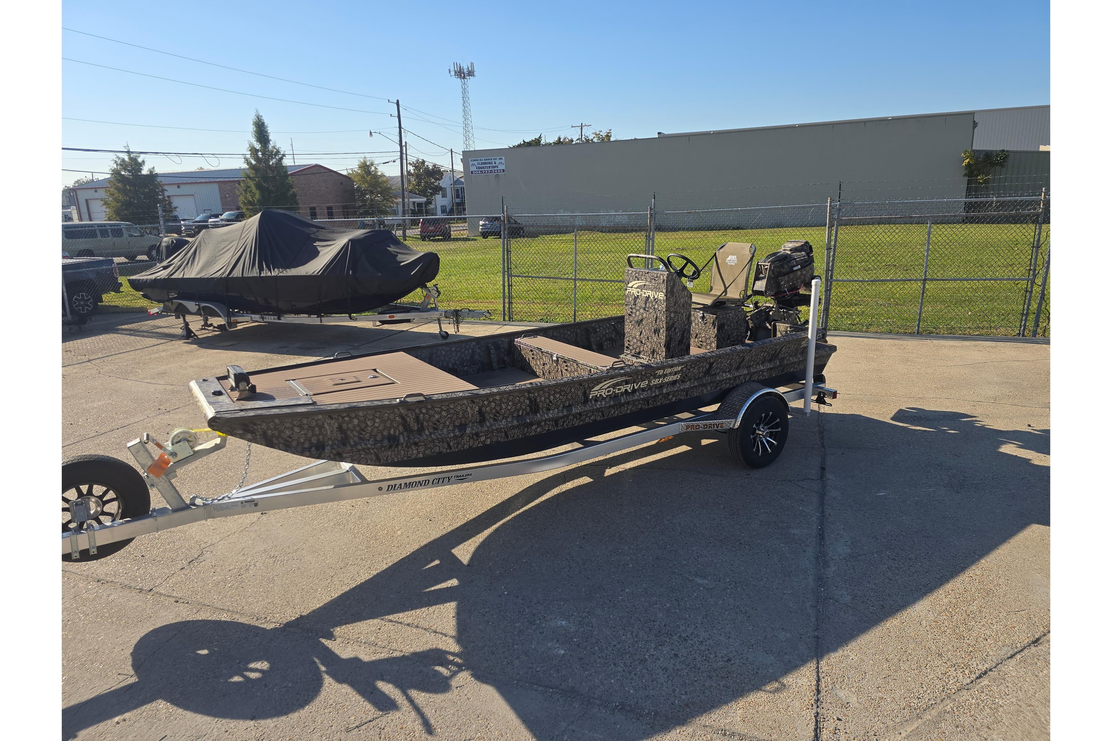 2026 Pro-Drive 1856 SBX TD boat on trailer, camo design, parked outdoors.