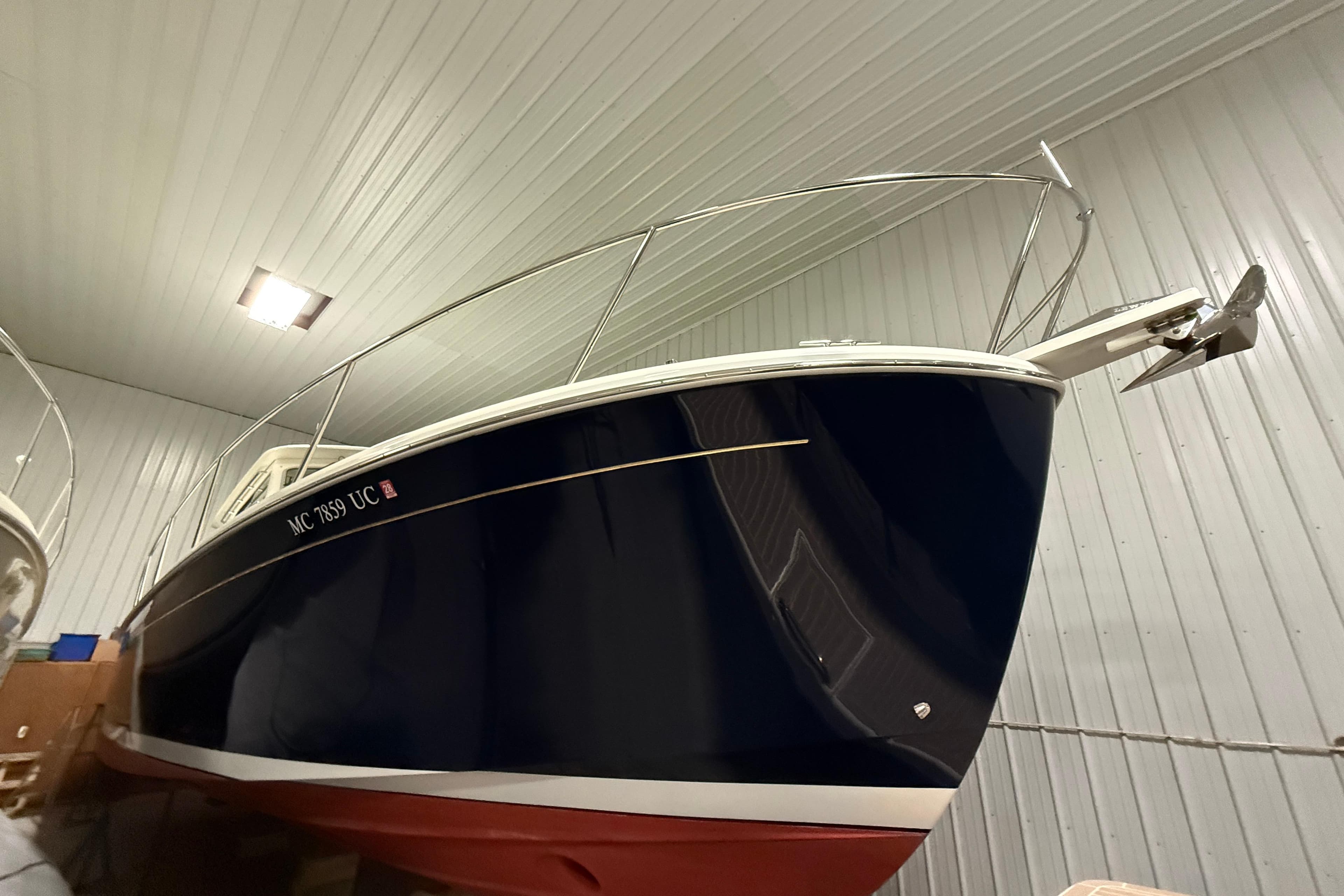 2017 Back Cove 37 boat in indoor storage, showcasing sleek design and navy blue hull.
