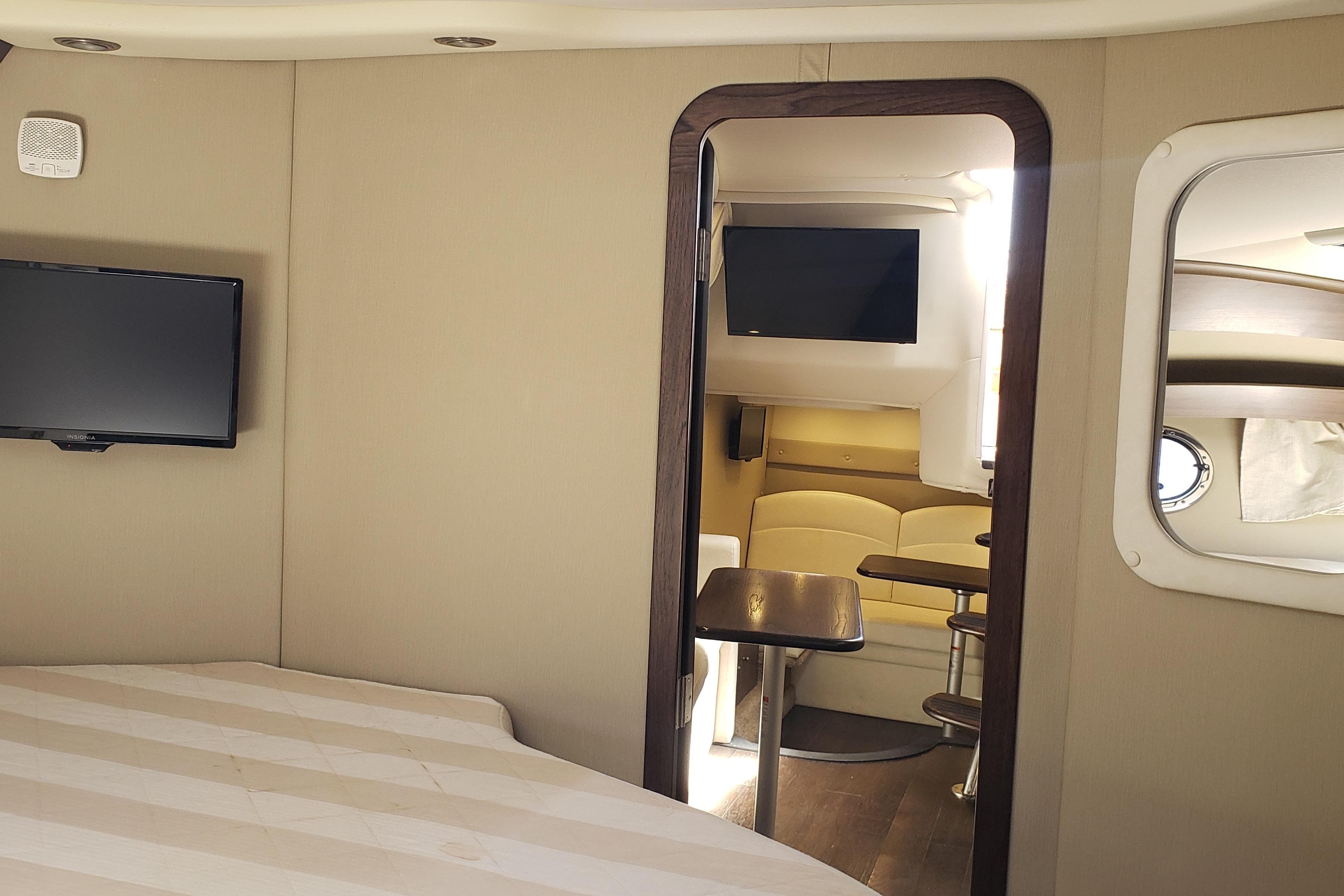Interior of 2019 Rinker EX 370 yacht with TV, seating, and table.