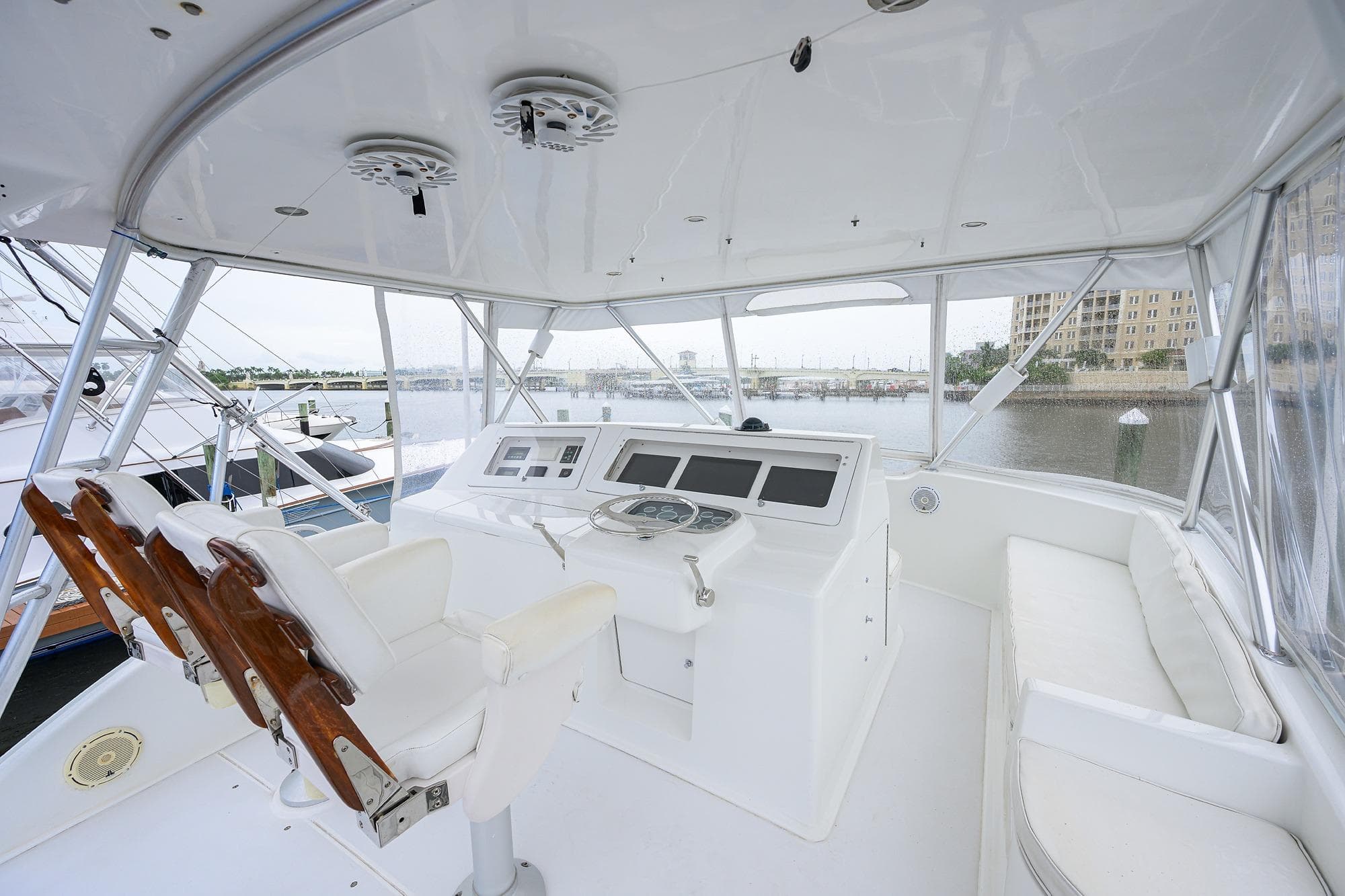 Interior view of 2004 Viking 48 Convertible yacht helm with white seating and controls.