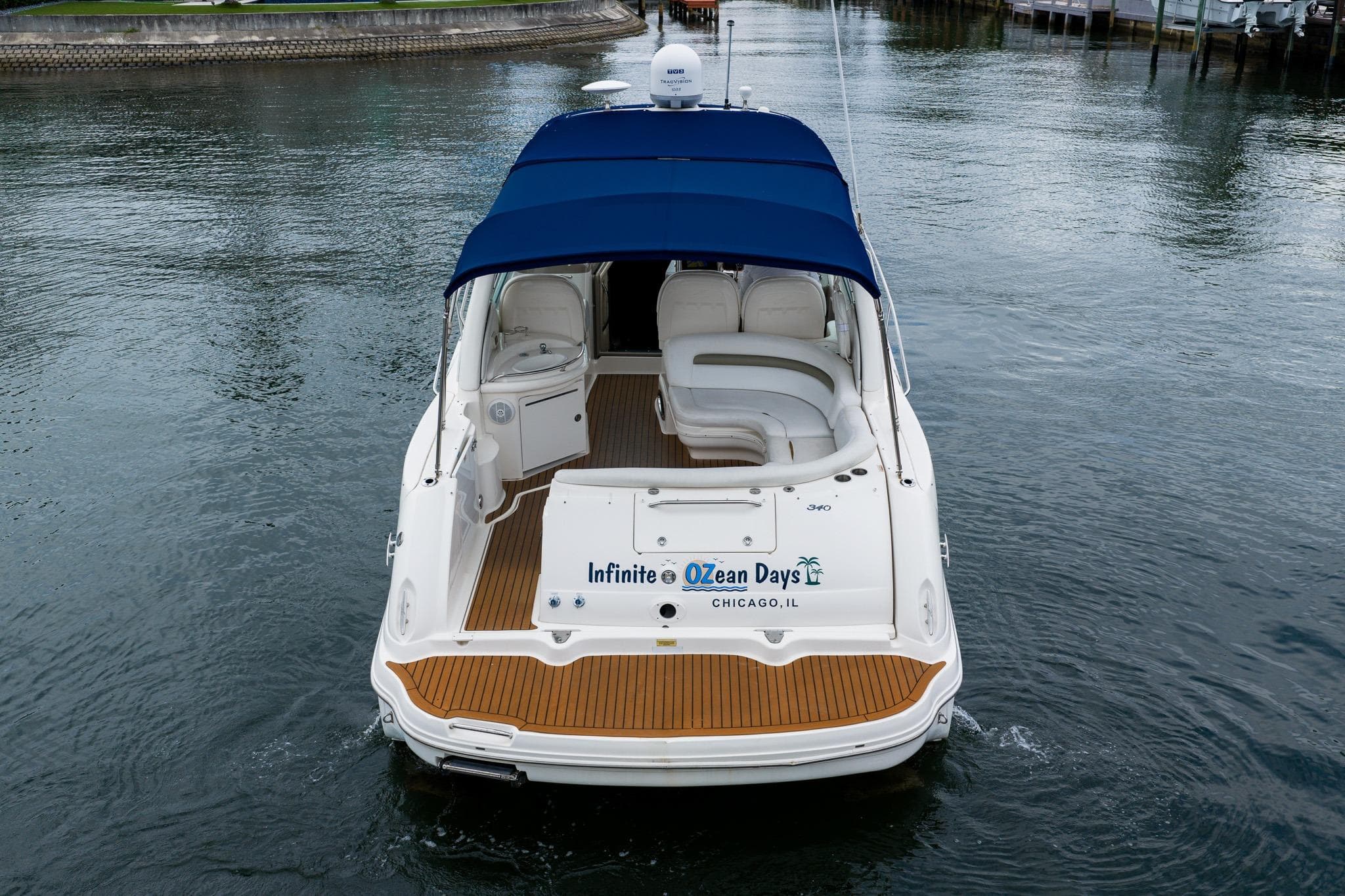 2007 Sea Ray 340 Sundancer yacht with blue canopy on calm water.