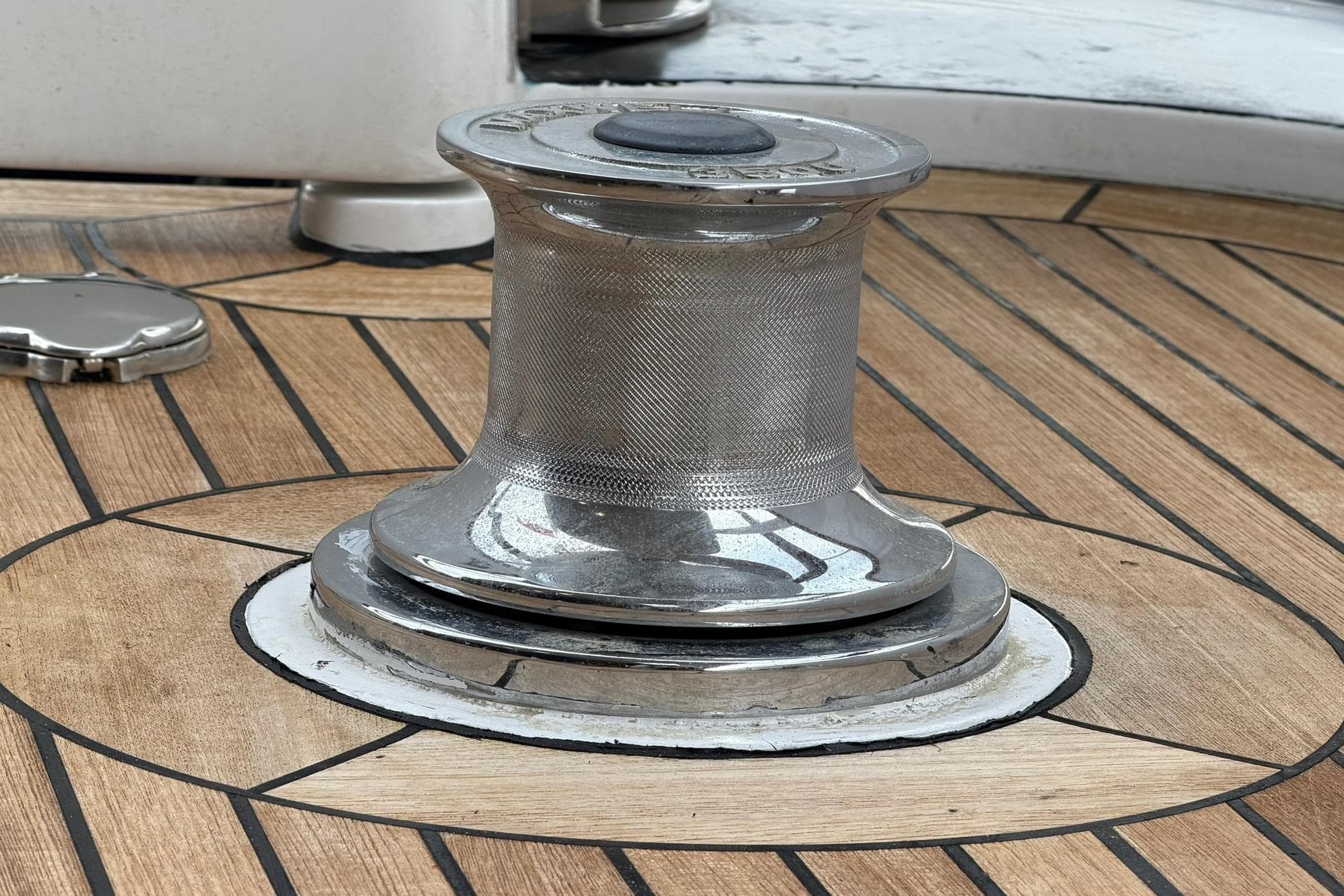Chrome winch on teak deck of 1990 Lowland Netship 97 yacht.