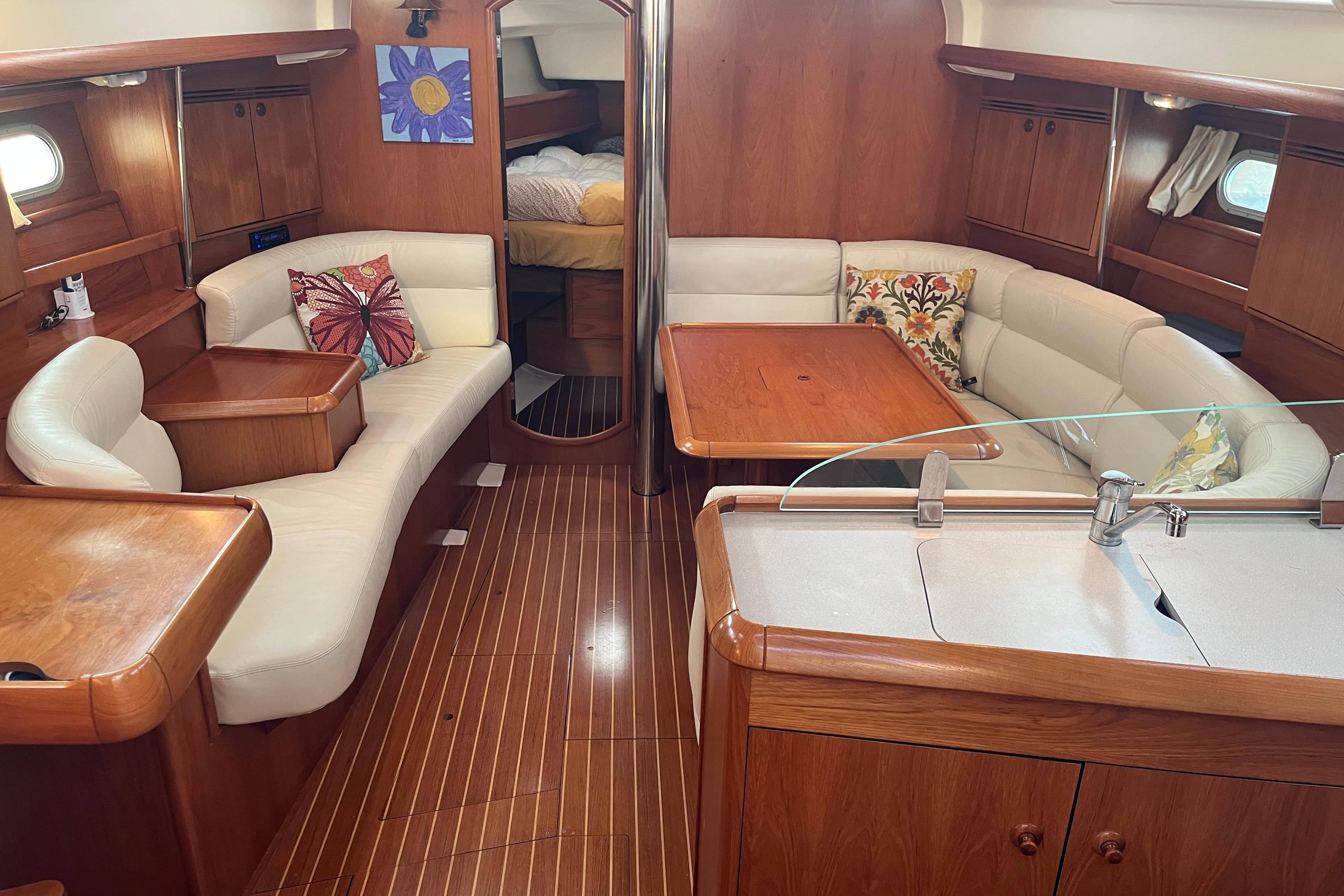 Interior of 2005 Jeanneau Sun Odyssey 40.3 yacht with wood finish and cozy seating.