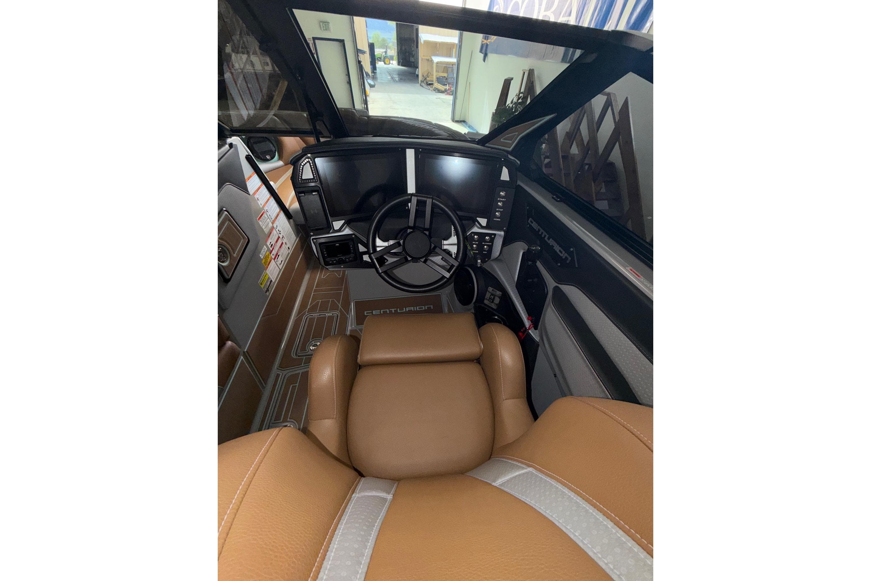 Interior view of 2025 Centurion Ri245 boat cockpit with modern steering and controls.