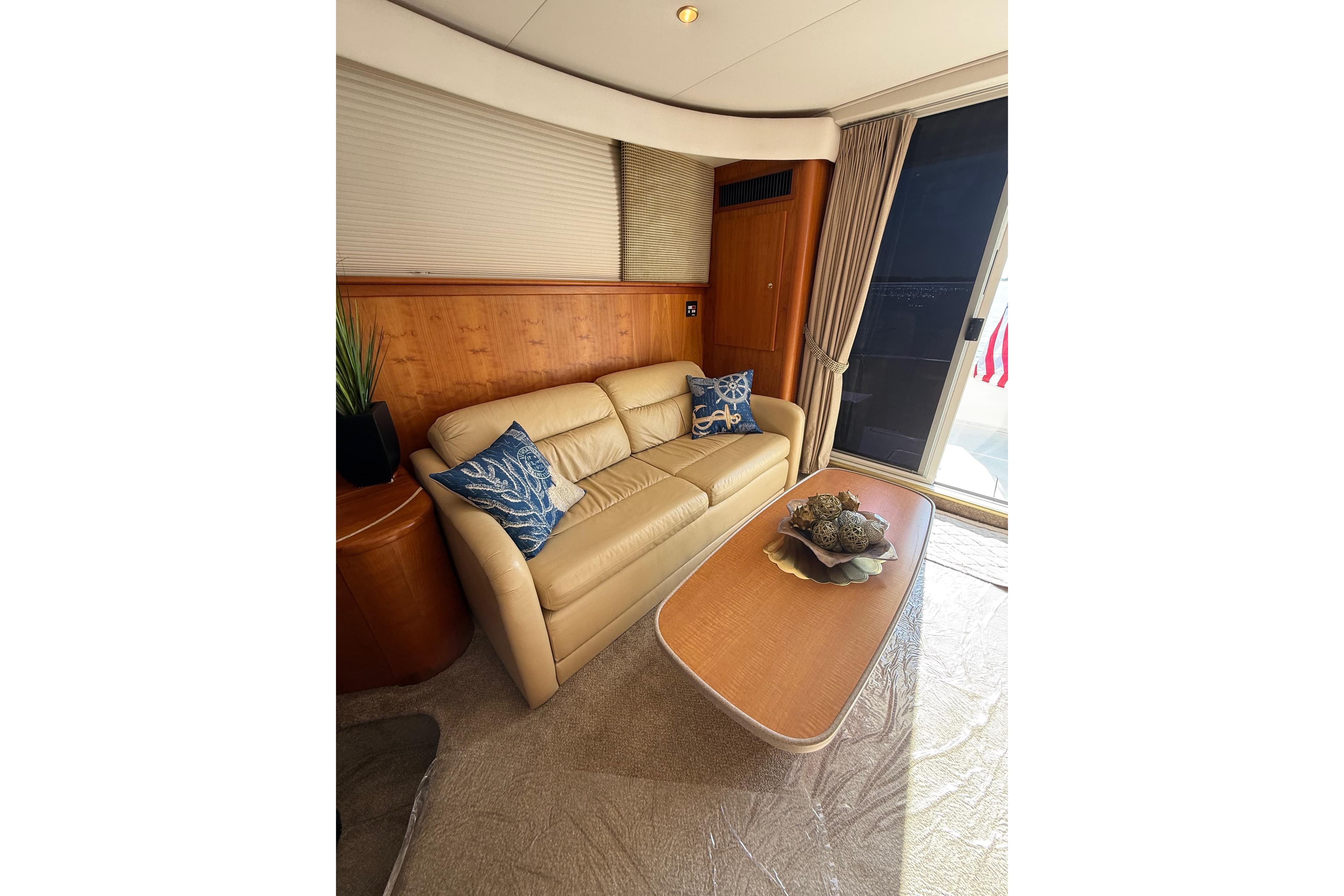 Luxurious interior of 2001 Silverton 42 Convertible yacht with beige sofa and decorative pillows.