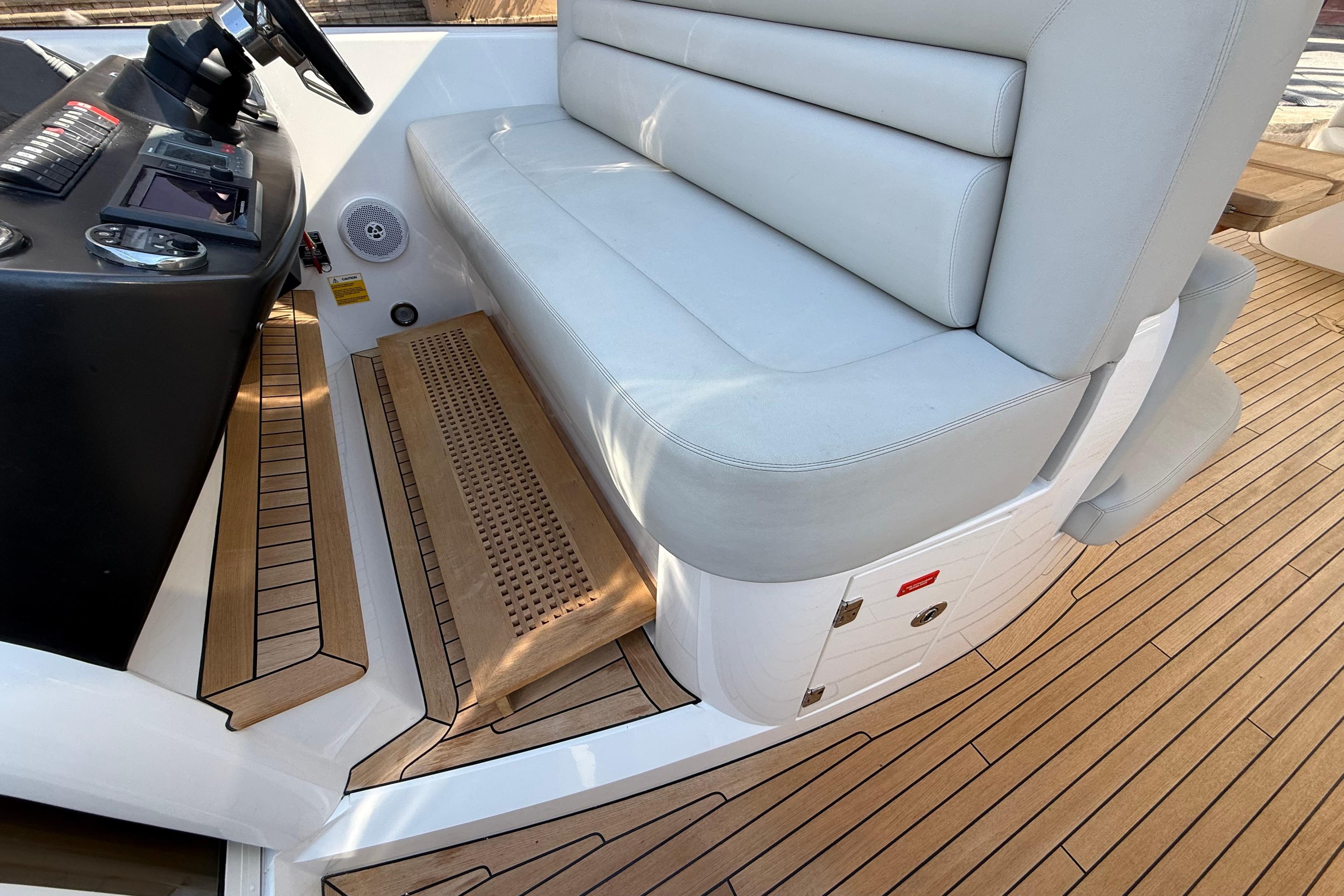 Sunseeker Predator 60 yacht interior, featuring helm seat and teak flooring, 2012 model.