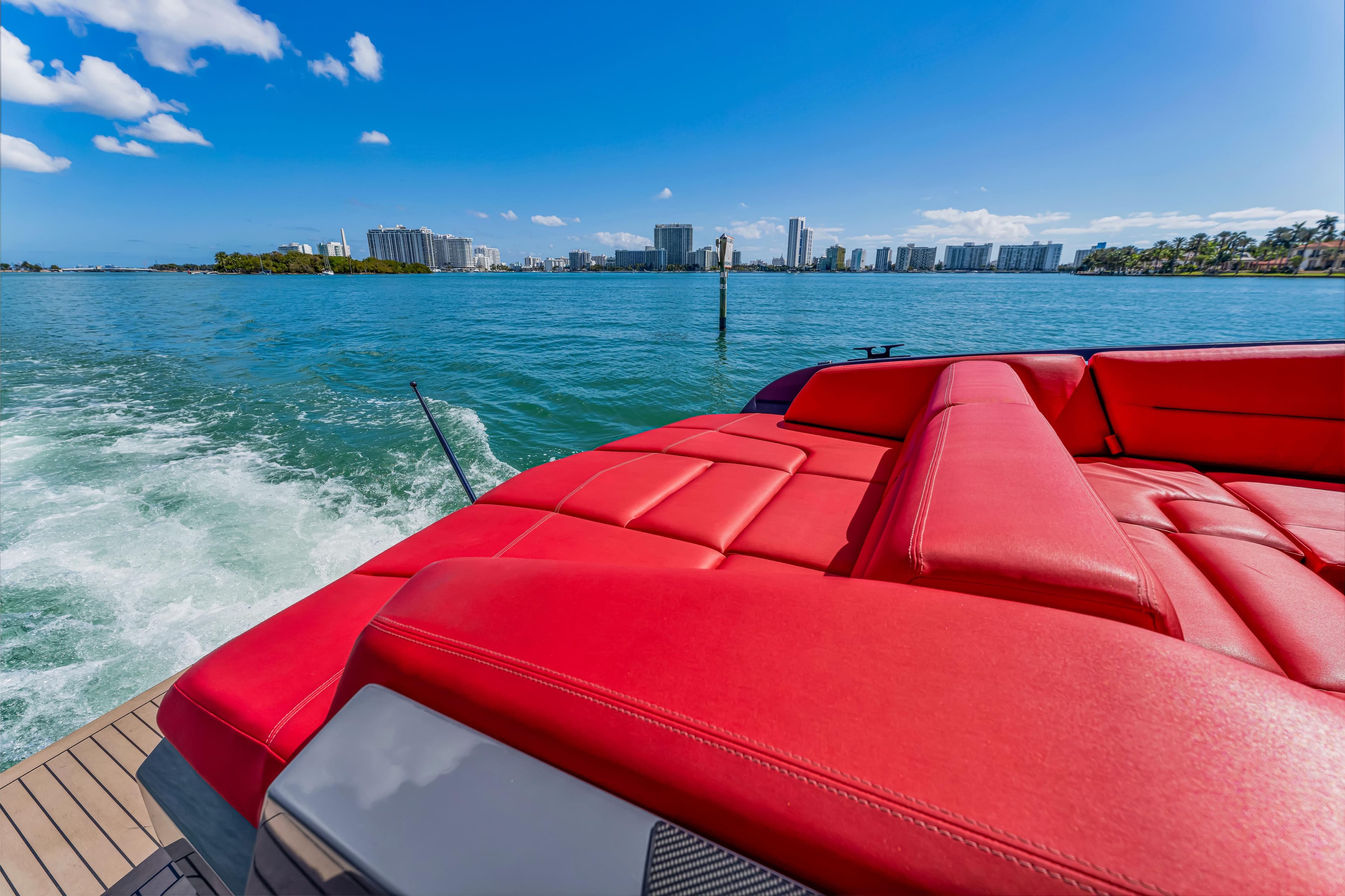 Luxurious 2021 Vanquish Yachts 45 with red seating, cruising on a sunny day.