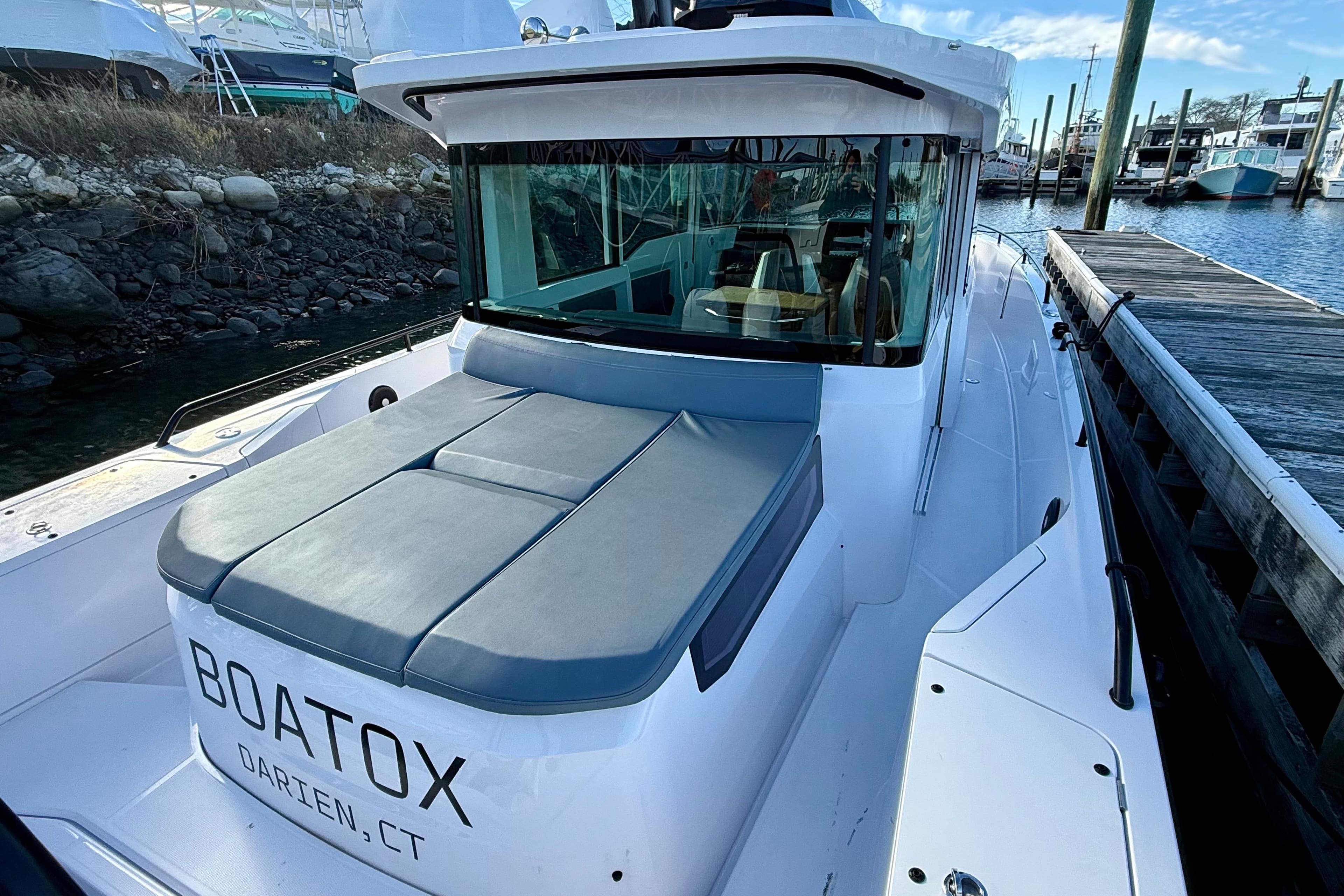2023 Axopar 37 Cross Cabin boat docked, featuring sleek design and comfortable seating.